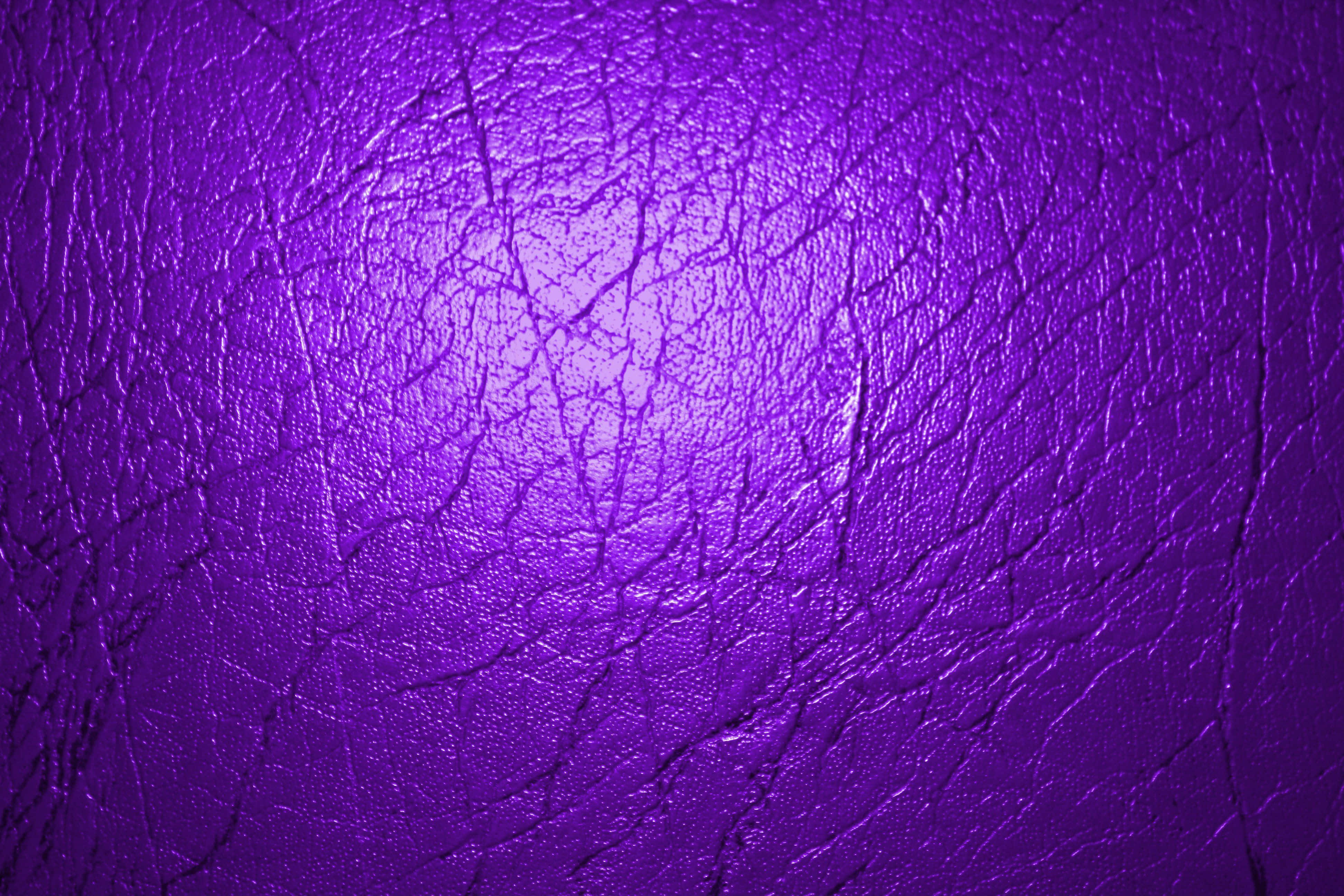 Purple Textured 桌布 壁紙 — 充滿活力的紫色紋理皮革特寫，帶有明亮的中央高光和深層皺褶。