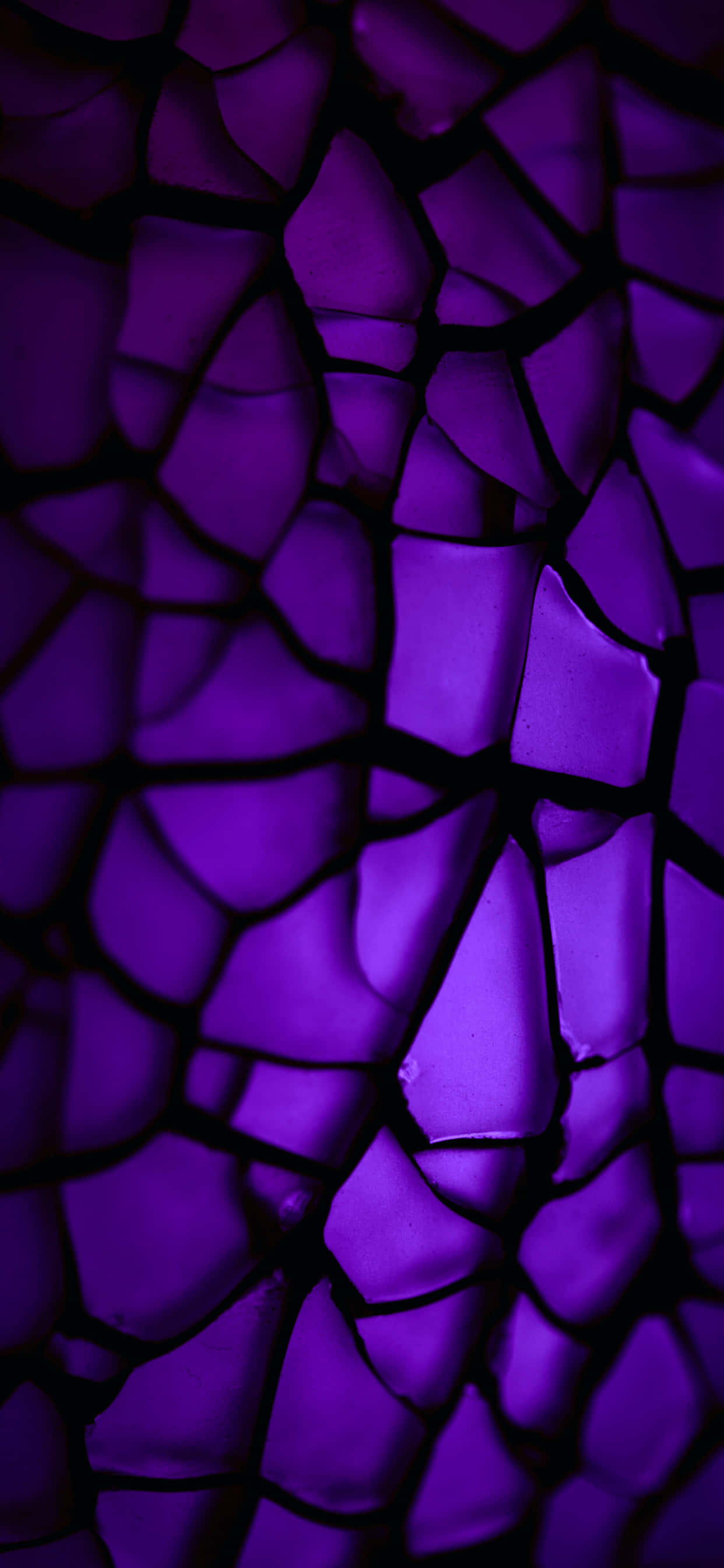 Purple Abstract 桌布 壁紙 — 充滿活力的紫色裂紋玻璃碎片在深色陰影中發光，形成破碎的抽象紋理。