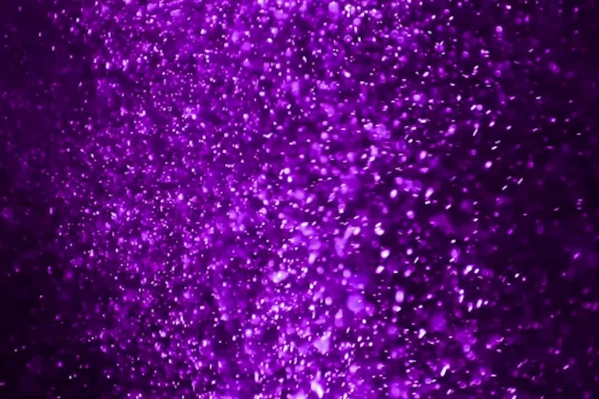 Purple Glitter 桌布 壁紙 — 充滿活力的紫色閃粉紋理，閃爍的顆粒在深色背景上發光。