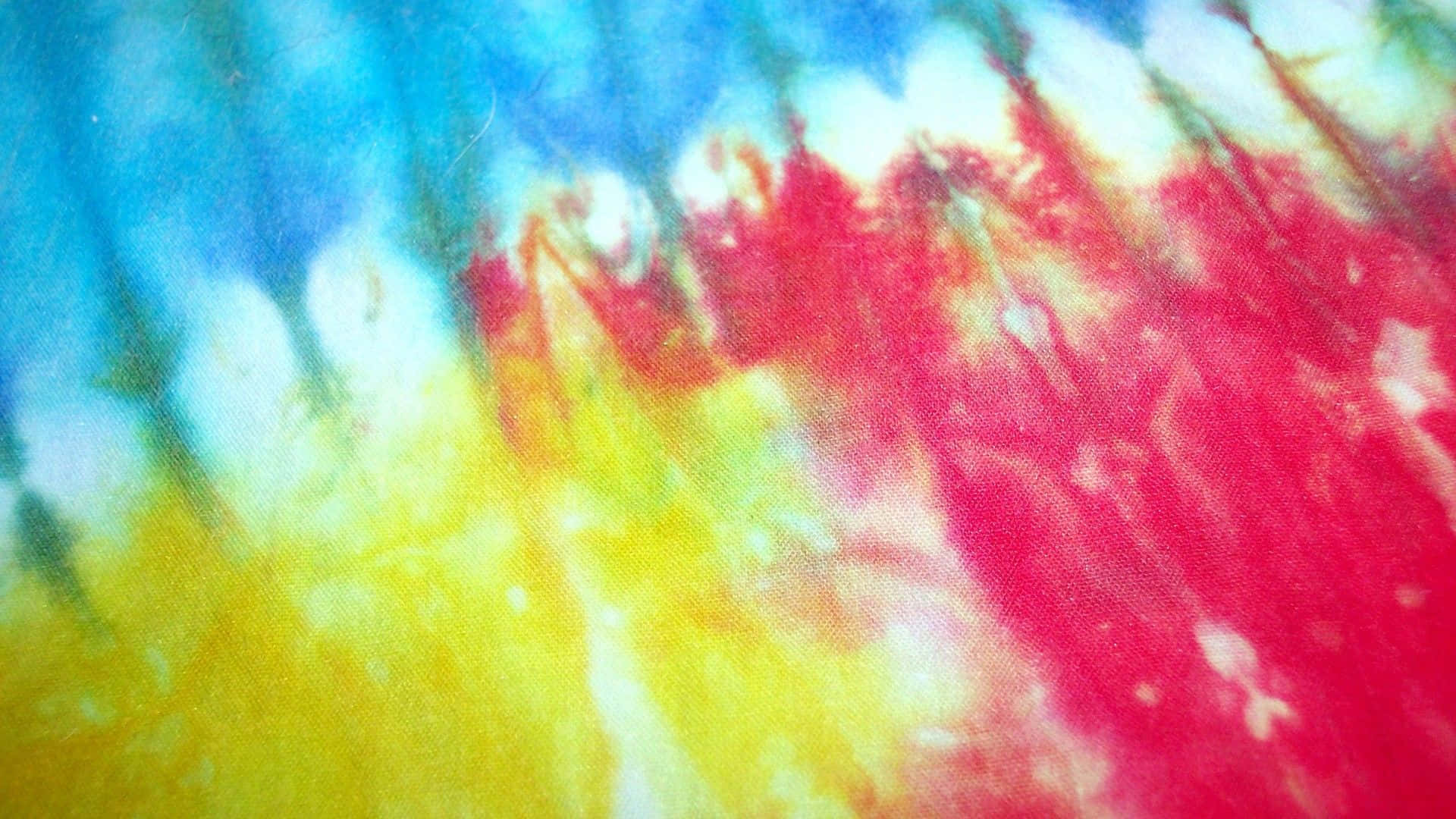 扎染 桌布 壁紙 — 充滿活力的紮染布料以鮮明的紅、黃、藍、白色旋轉，創造出迷幻的抽象圖案。