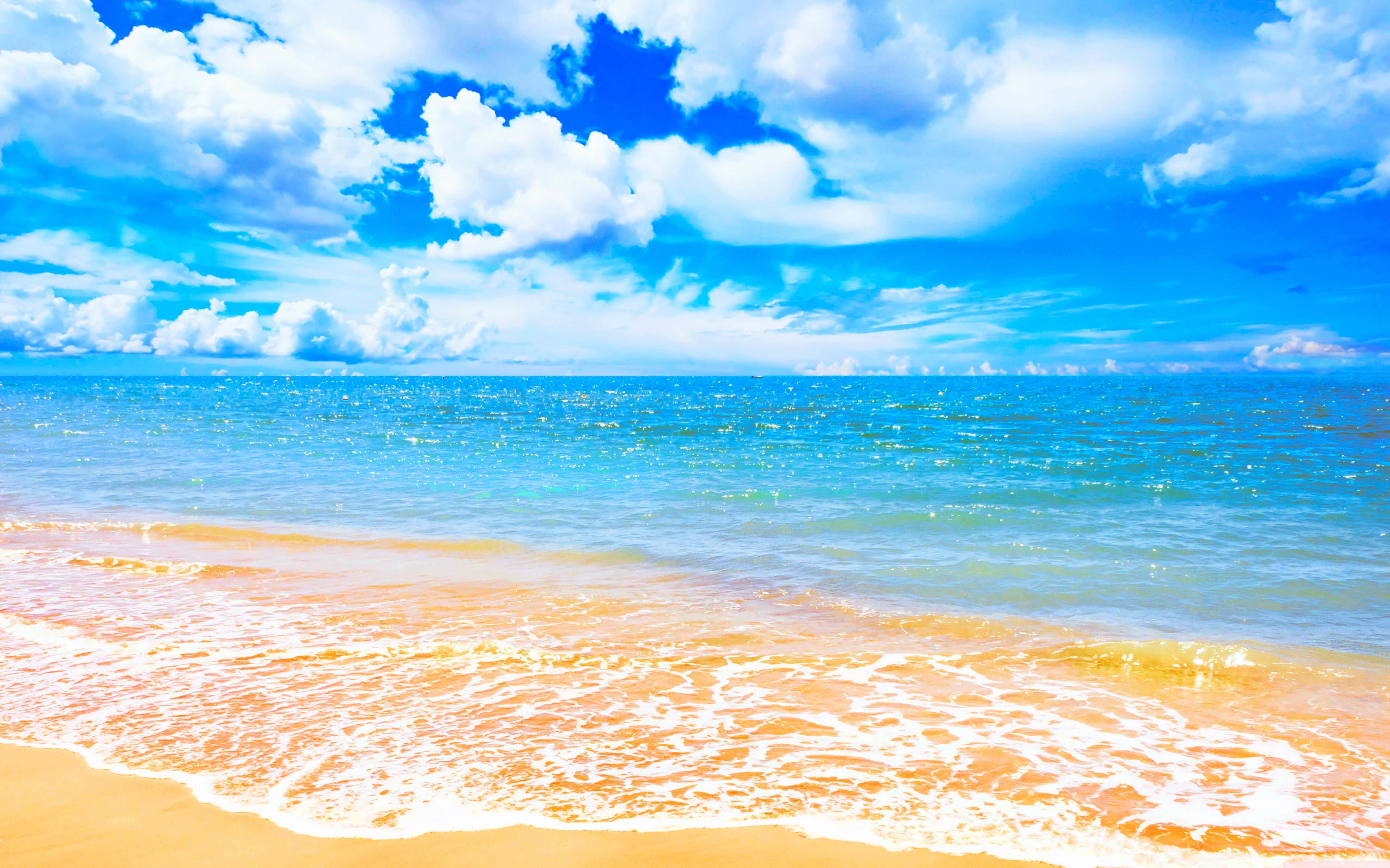 Beach Desktop 桌布 壁紙 — 充滿活力的綠松石色海浪拍打在金色沙灘上，天空湛藍，飄滿蓬鬆的白雲。