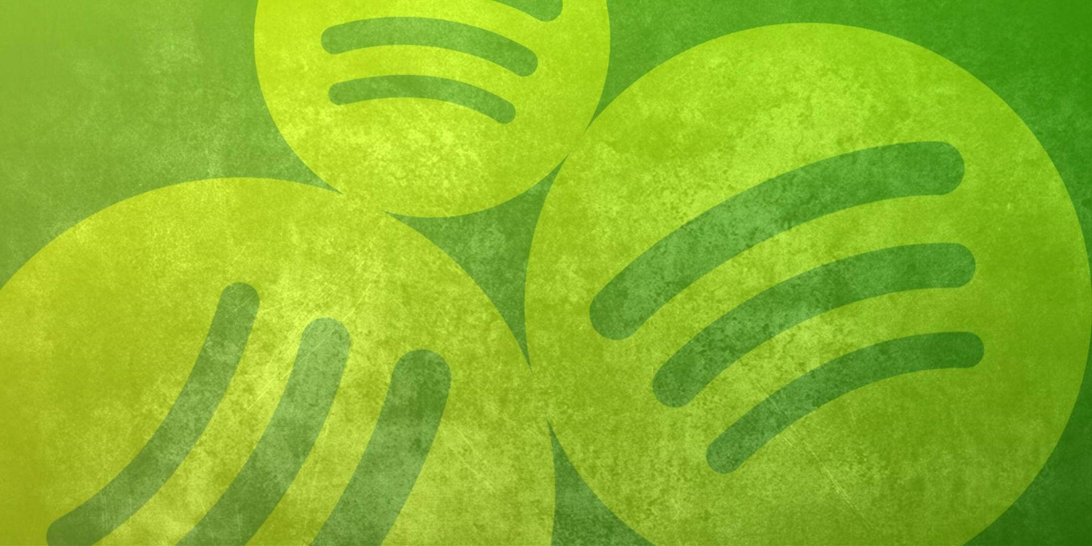 Spotify 桌布 壁紙 — 充滿活力的綠色Spotify標誌重疊在帶有萊姆綠和森林綠漸變色調的紋理背景上。