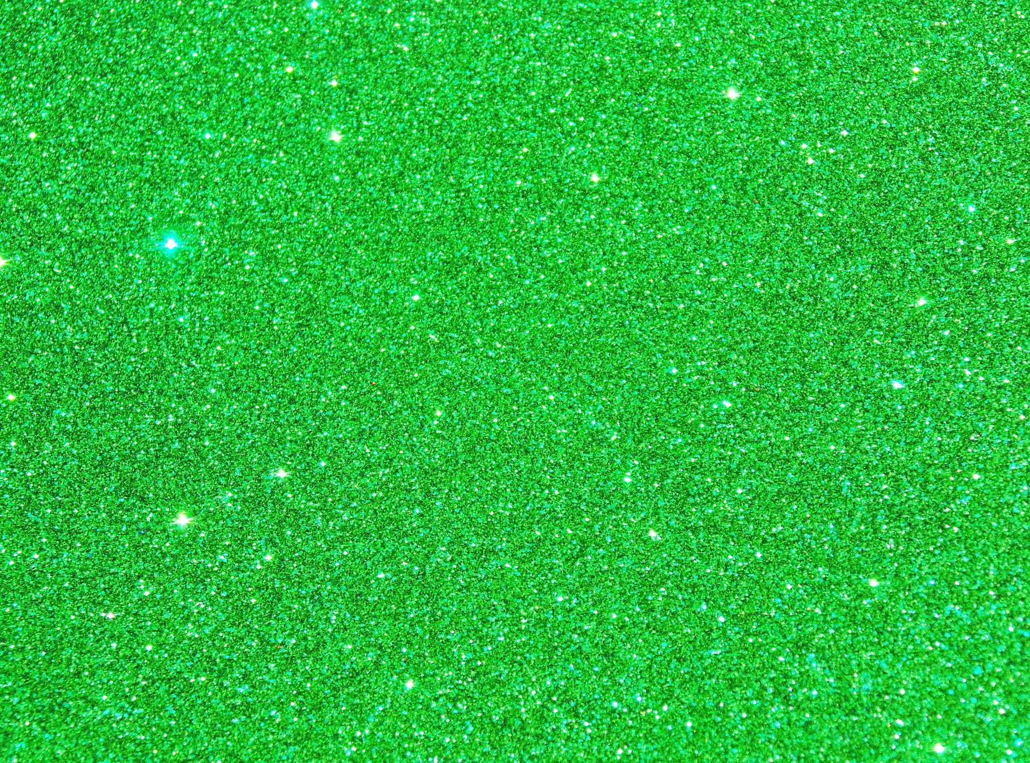 Green Glitter 桌布 壁紙 — 充滿活力的綠色亮粉紋理，帶有閃爍亮點，覆蓋整個畫面。