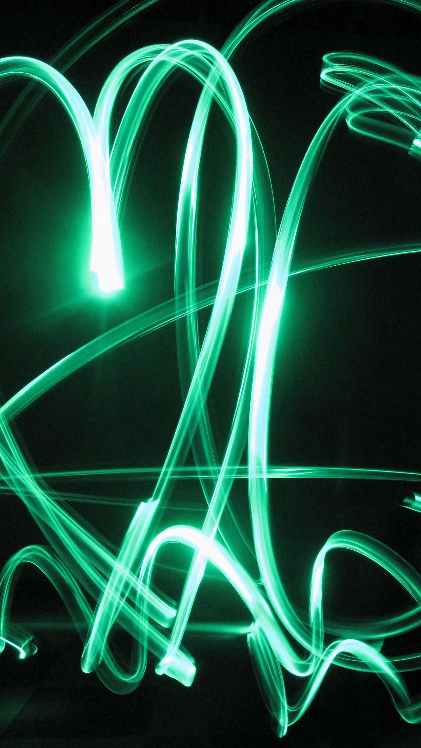 Green Led 桌布 壁紙 — 充滿活力的綠色光軌在漆黑的背景上動態旋轉，形成迷人的抽象構圖。
