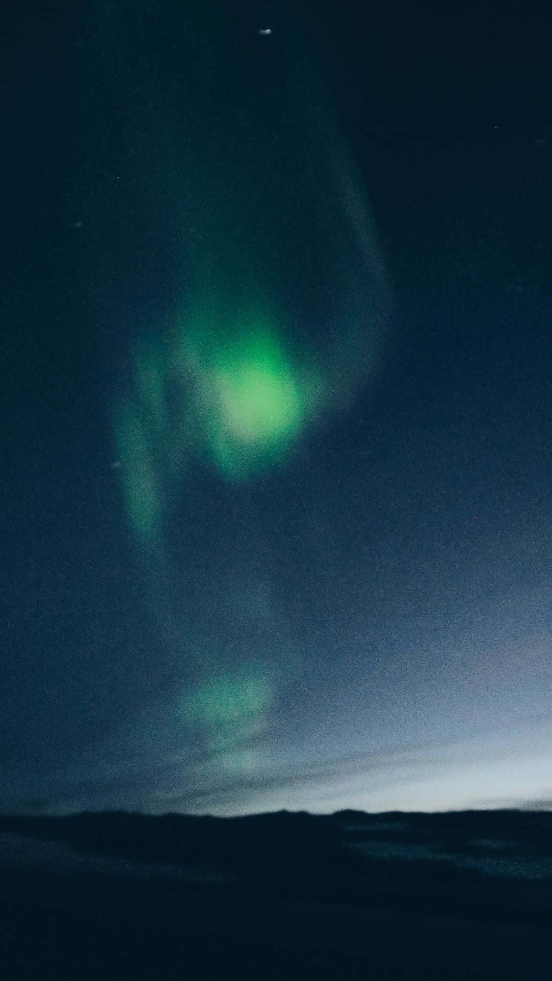 極光 桌布 壁紙 — 充滿活力的綠色北極光在繁星點點的夜空中舞動，上方是黑暗的剪影地平線。