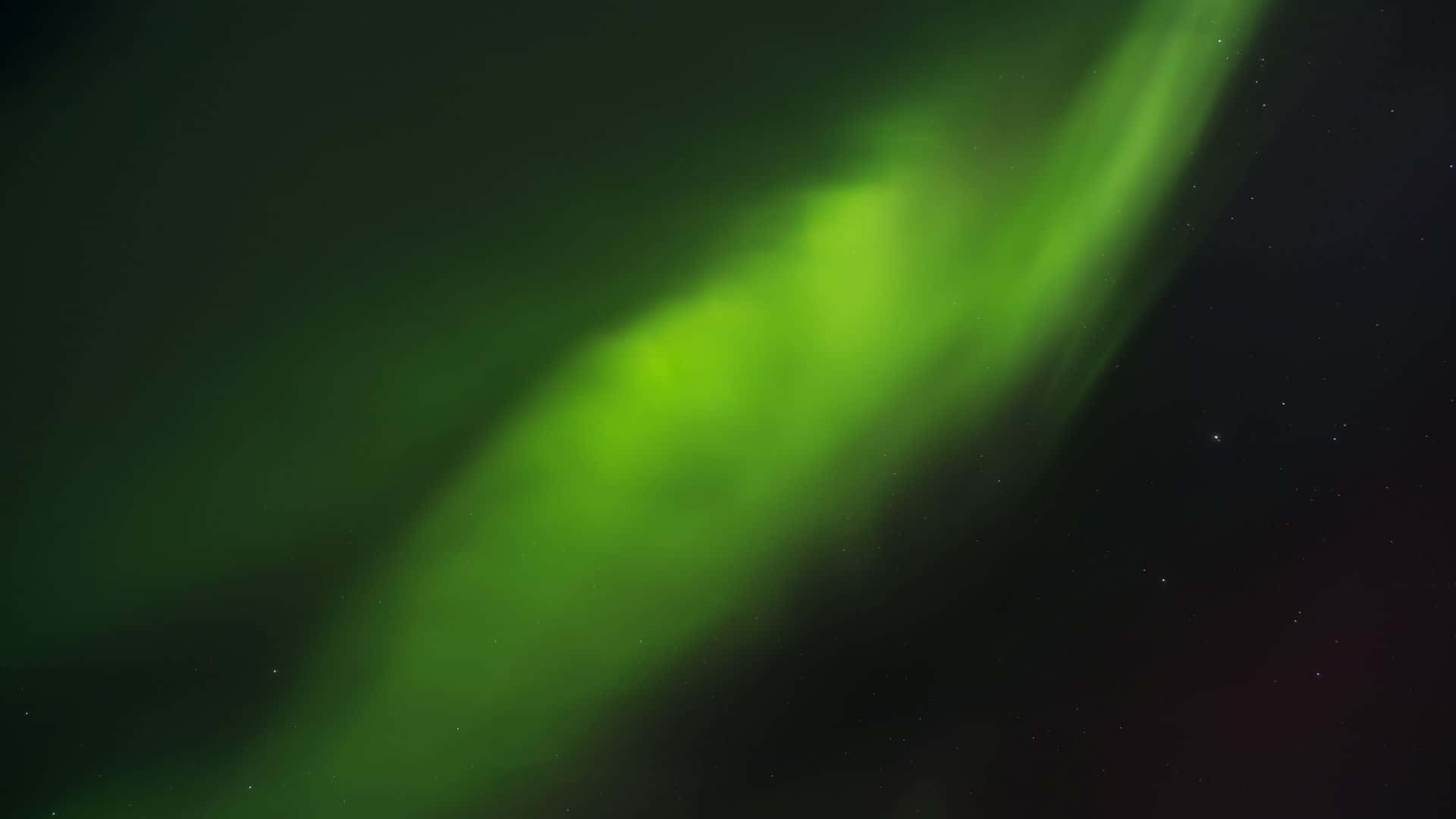 極光 桌布 壁紙 — 充滿活力的綠色北極光在繁星點點的夜空中舞動，帶有柔和發光的絲帶。