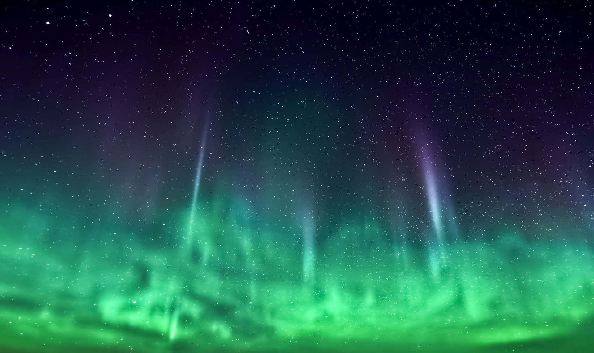 Aurora 桌布 壁紙 — 充滿活力的綠色和紫色極光在繁星點點的夜空中舞動，宇宙射線向下劃過。