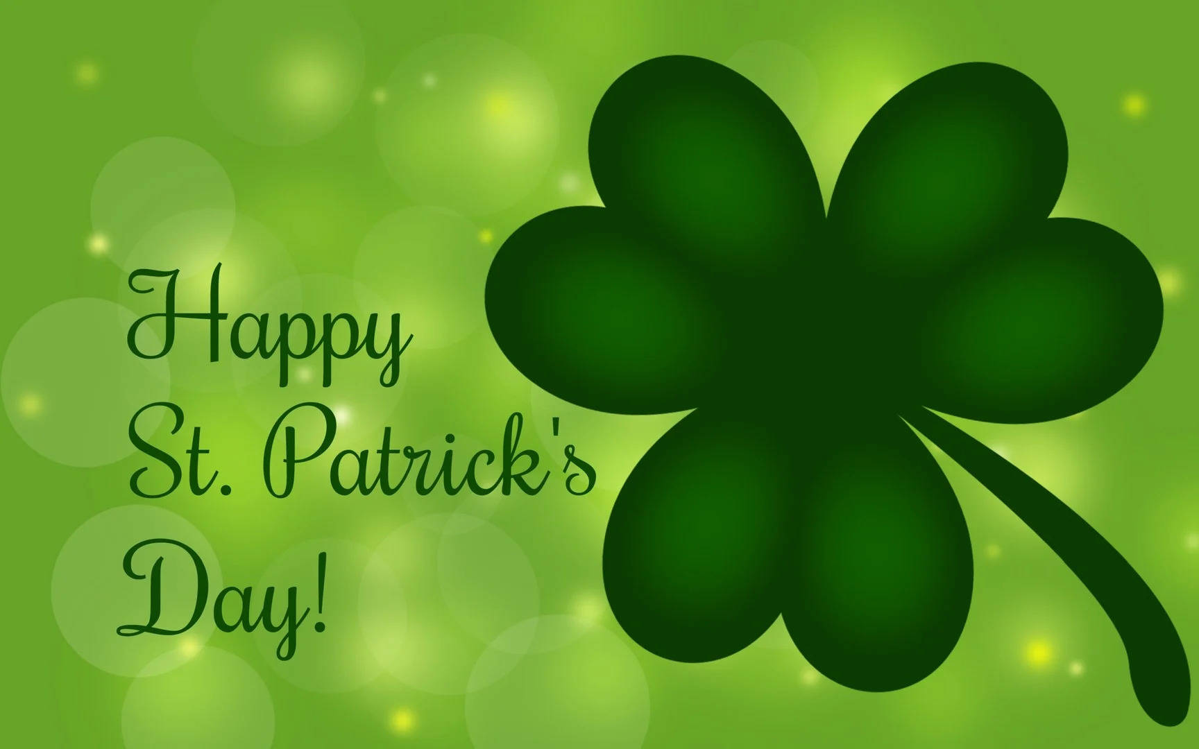 Happy St Patricks Day 桌布 壁紙 — 充滿活力的綠色四葉草，帶有發光散景背景和草書Happy St. Patrick's Day文字。