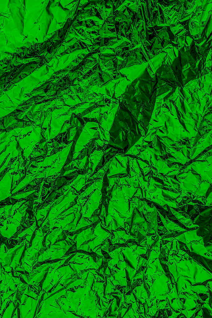 Green Texture 桌布 壁紙 — 充滿活力的綠色皺紋箔紙，帶有銳利的摺痕和反射亮點，營造出動態的紋理表面。