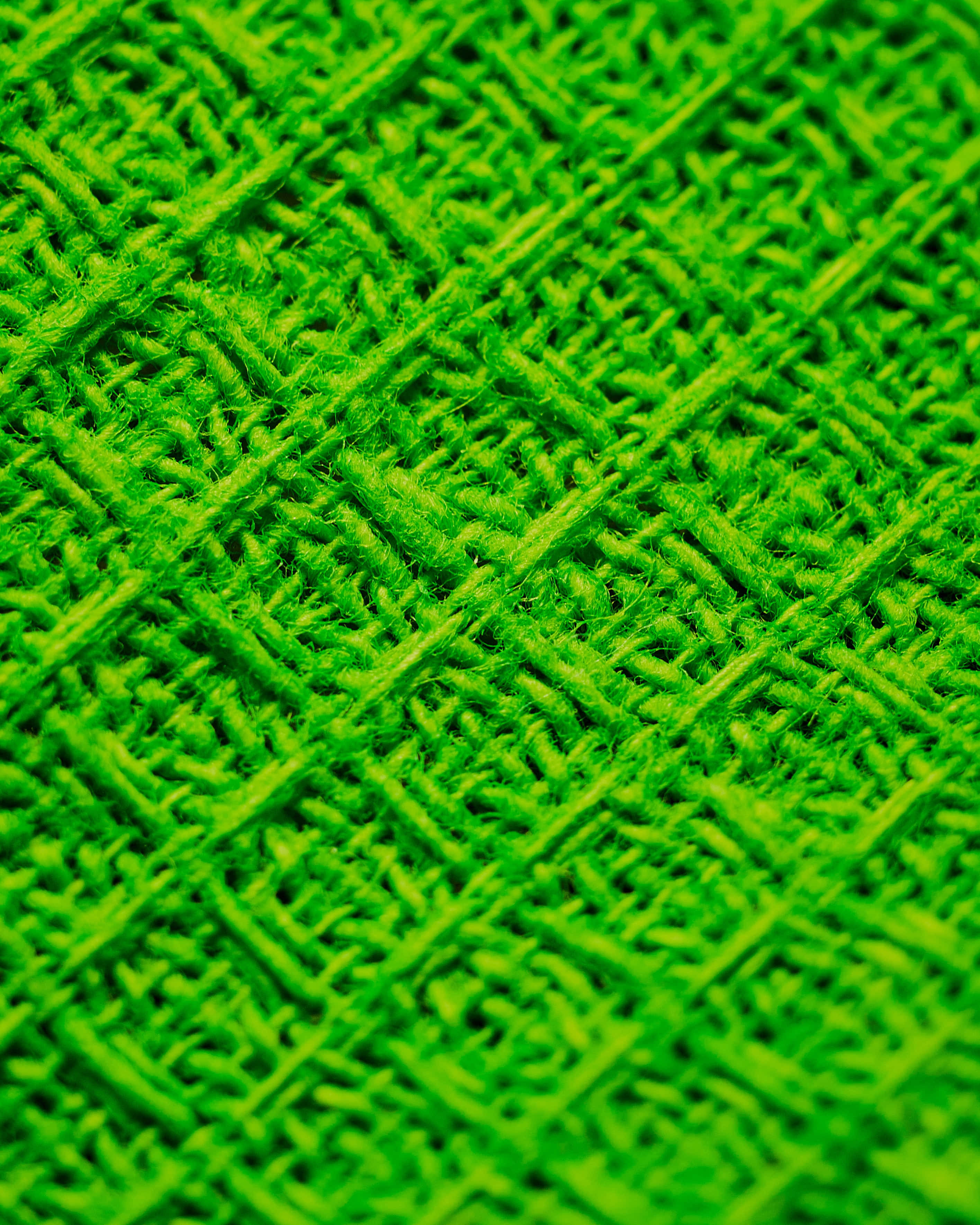 Green Texture 桌布 壁紙 — 充滿活力的綠色編織紡織品特寫，帶有紋理對角線圖案和絨毛纖維。