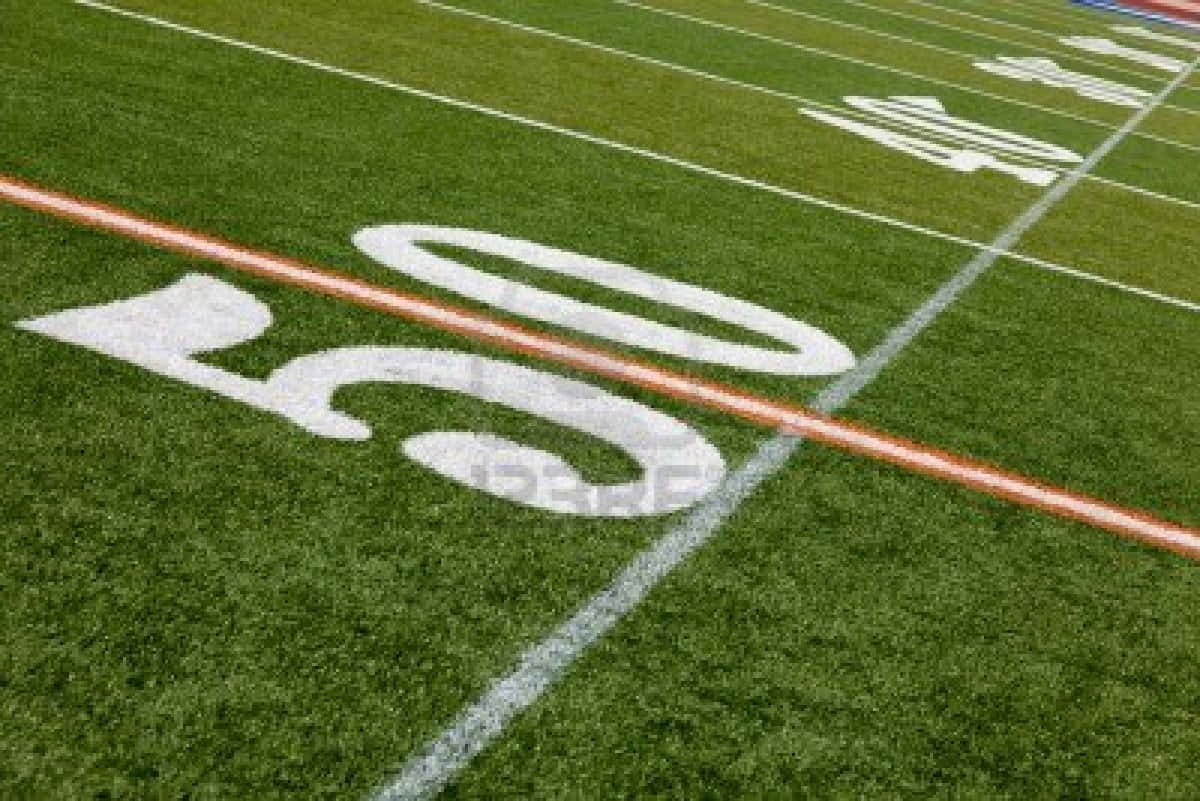 Football Field 桌布 壁紙 — 充滿活力的綠色足球場特寫，帶有粗體白色50碼線標記和橙色邊界條紋。