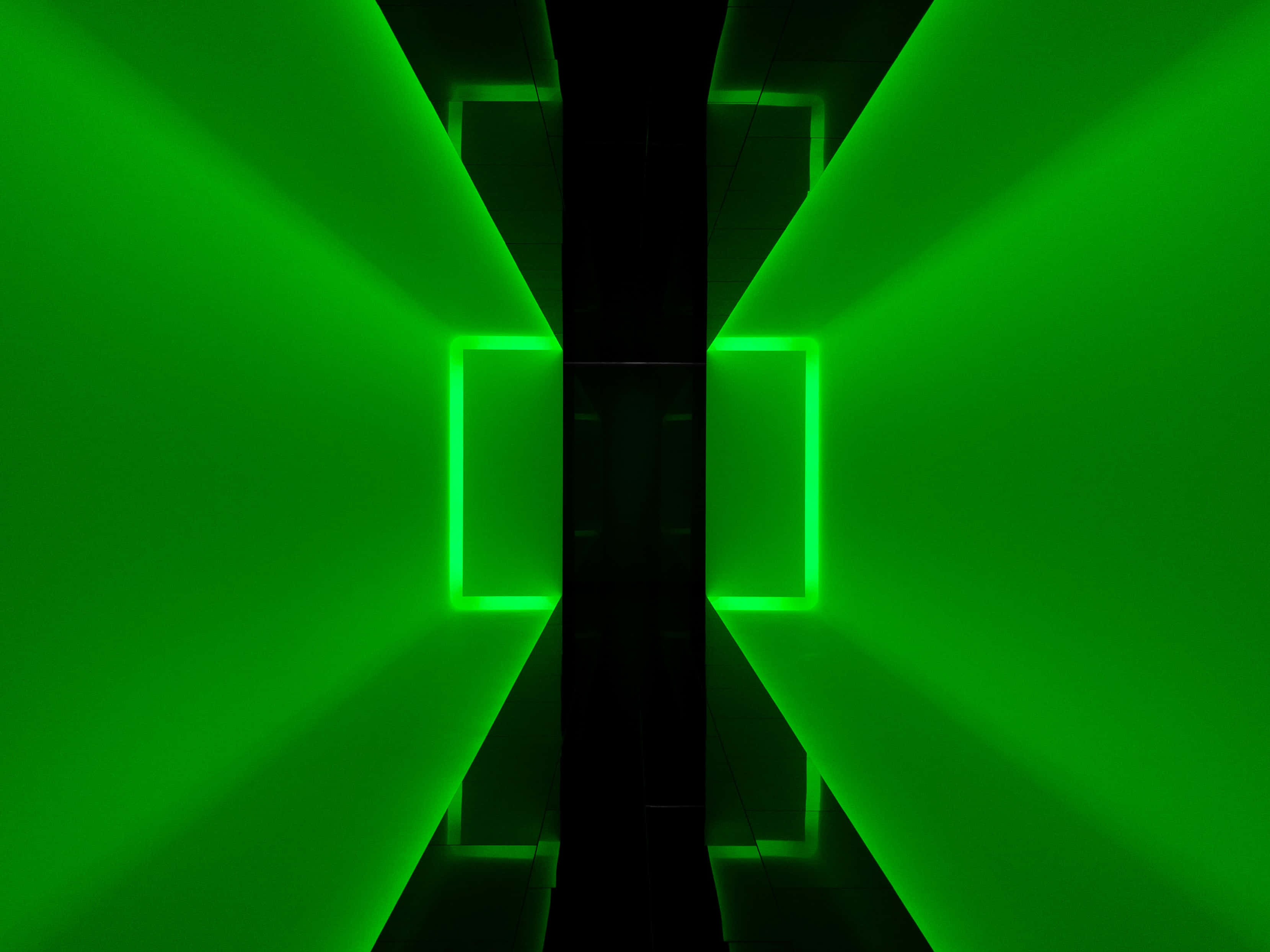 Laser 桌布 壁紙 — 充滿活力的綠色霓虹燈光束在黑暗的幾何走廊中形成對稱的矩形框架。