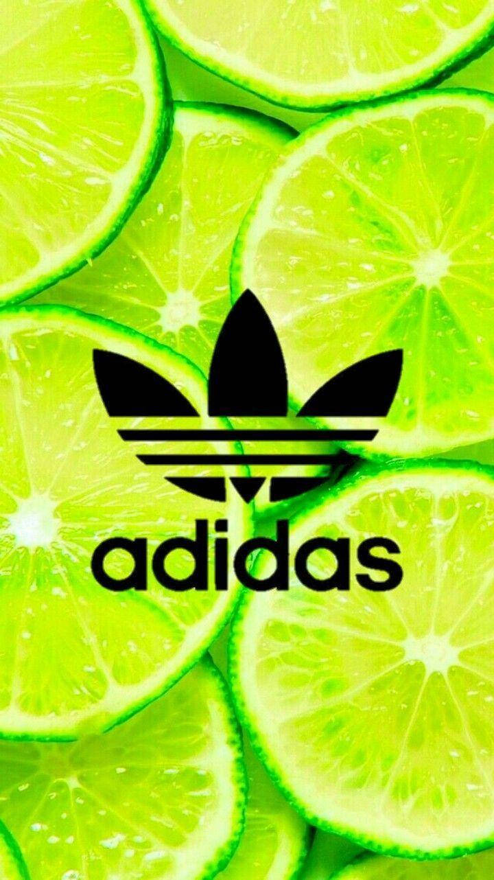 adidas iPhone 桌布 壁紙 — 充滿活力的萊姆片為大膽的黑色Adidas標誌和文字形成多汁的背景。