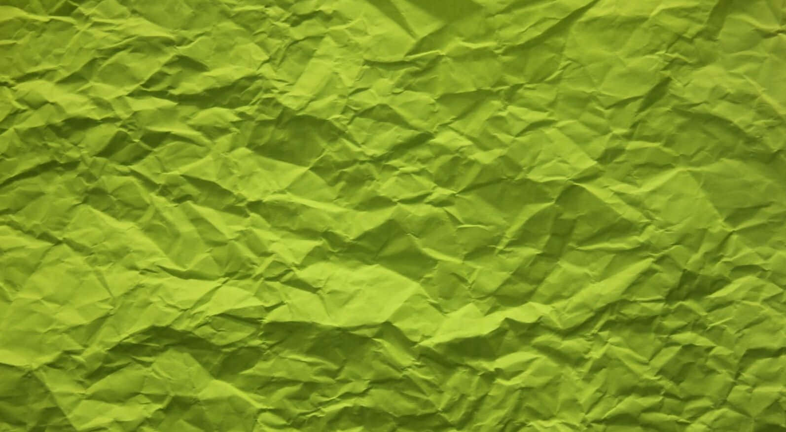 Lime Green Aesthetic 桌布 壁紙 — 充滿活力的萊姆綠色皺紙特寫，帶有紋理褶皺和陰影。
