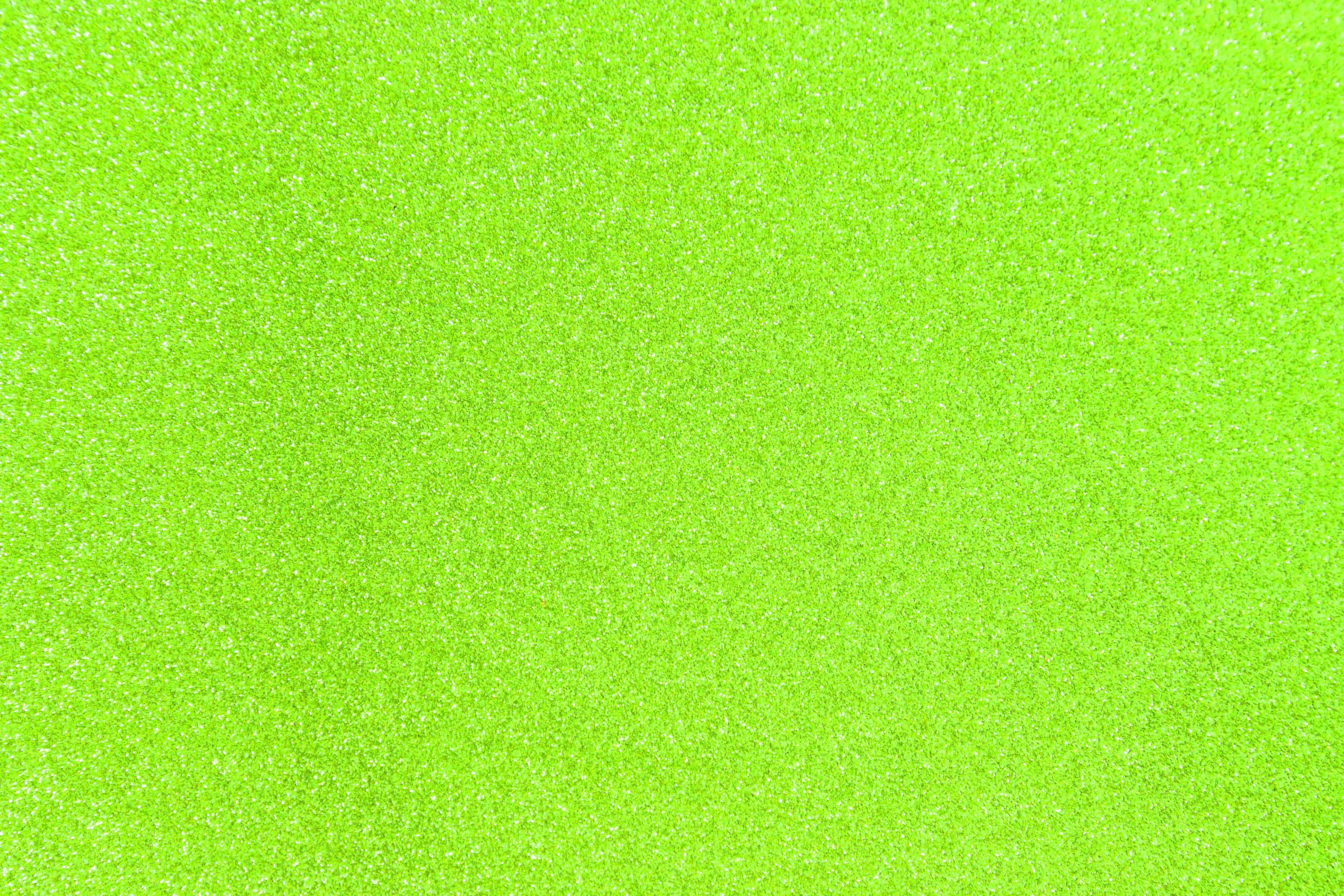 Green Glitter 桌布 壁紙 — 充滿活力的萊姆綠色紋理表面，帶有細微閃亮顆粒，營造出閃爍均勻的背景。