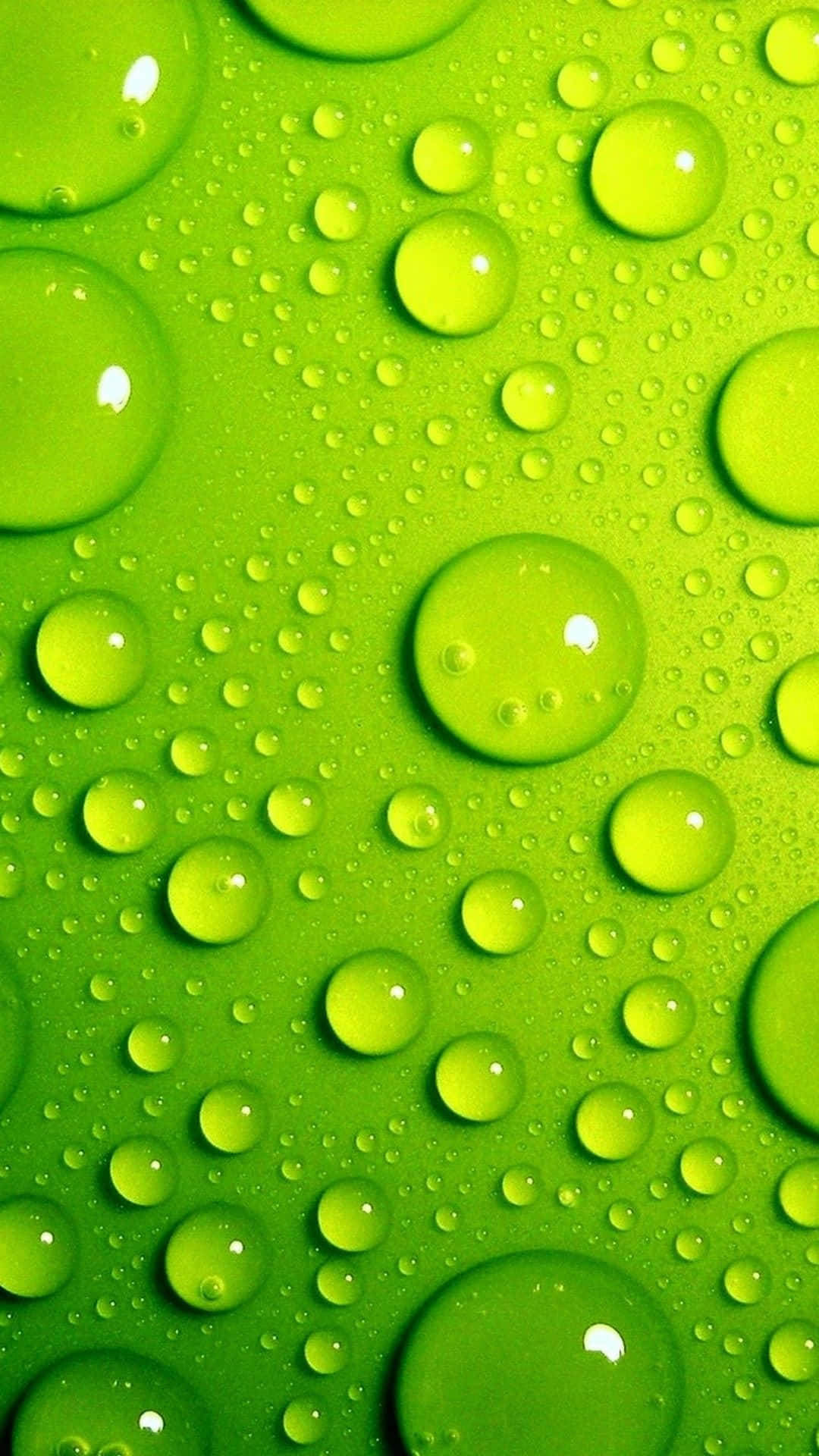 Lime Green 桌布 壁紙 — 充滿活力的萊姆綠色表面，點綴著閃閃發光的水滴，在微距特寫中反射光線。