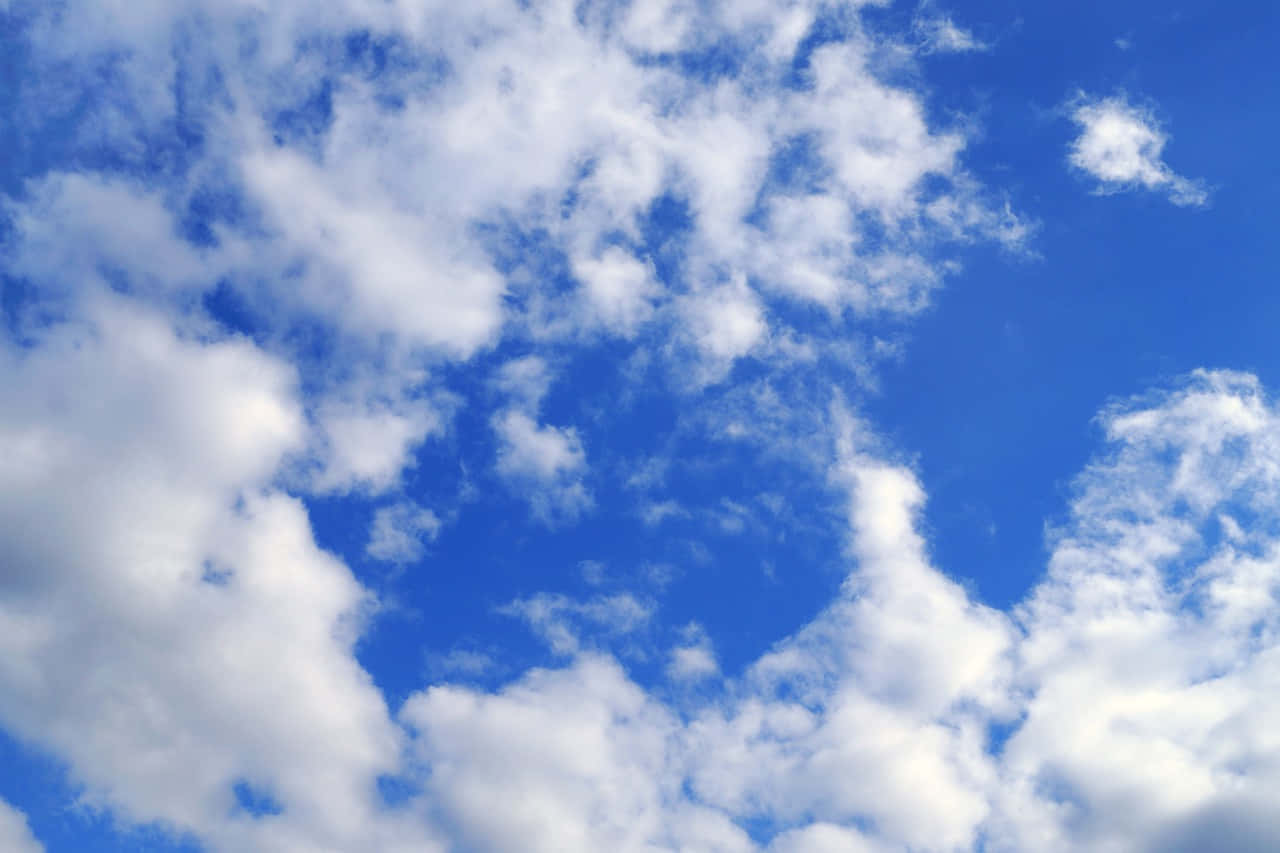 Heaven Clouds 桌布 壁紙 — 充滿活力的藍天，蓬鬆的白雲在晴朗的白天大氣中飄移。