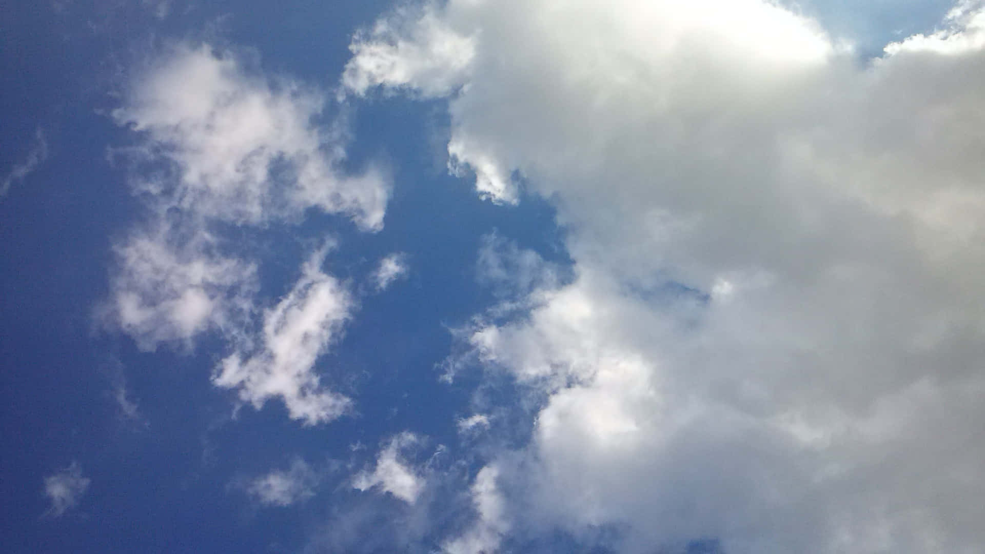 SKY-25 壁紙 — 充滿活力的藍天，蓬鬆的白雲在畫面中飄移。