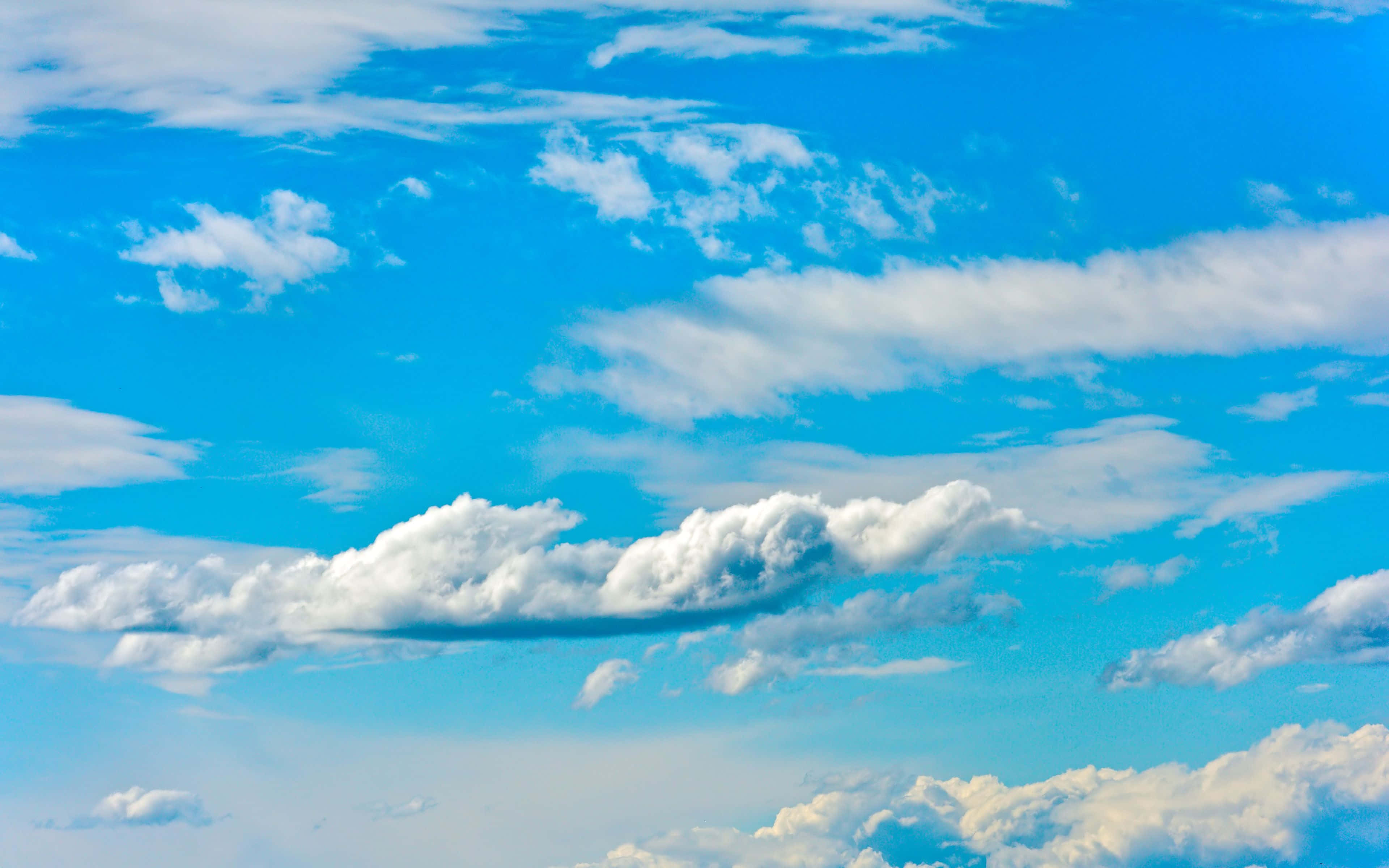 Beautiful Sky 桌布 壁紙 — 充滿活力的藍天，飄浮著蓬鬆的白雲，在晴朗的夏日裡緩緩移動。