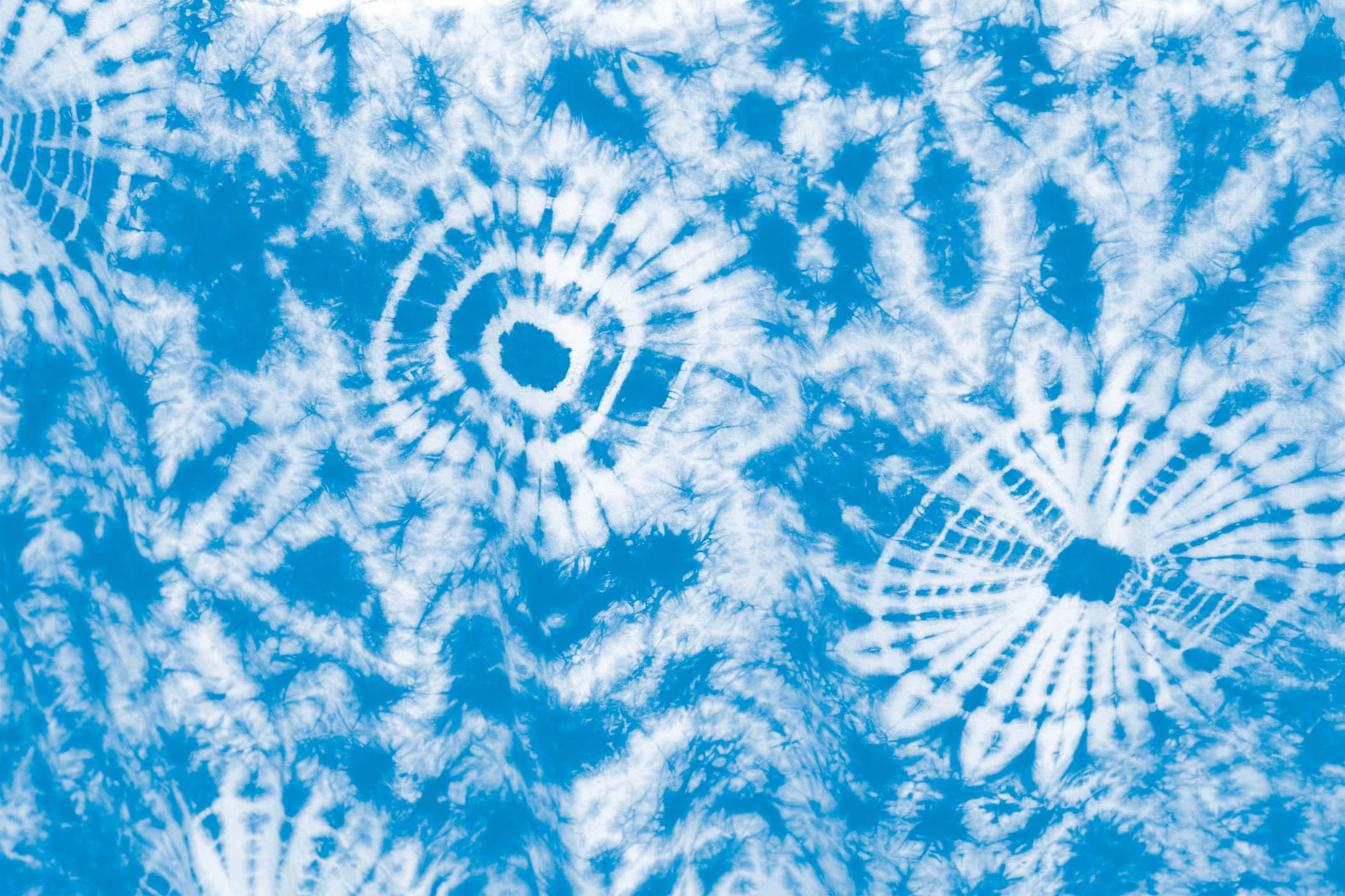 High Resolution Tie Dye 桌布 壁紙 — 充滿活力的藍白紮染布料，帶有複雜的螺旋和太陽爆發圖案。