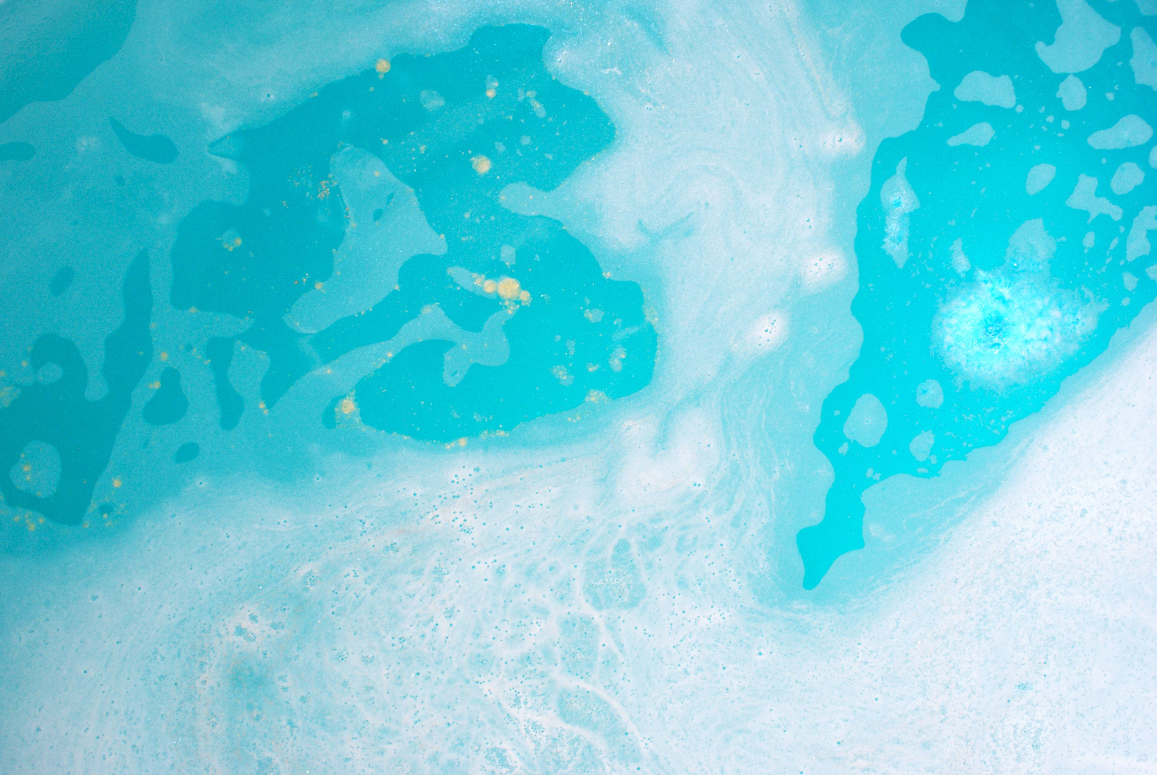 Lush 桌布 壁紙 — 充滿活力的藍綠色和白色液體漩渦，帶有金色斑點，形成動態的抽象流體藝術構圖。