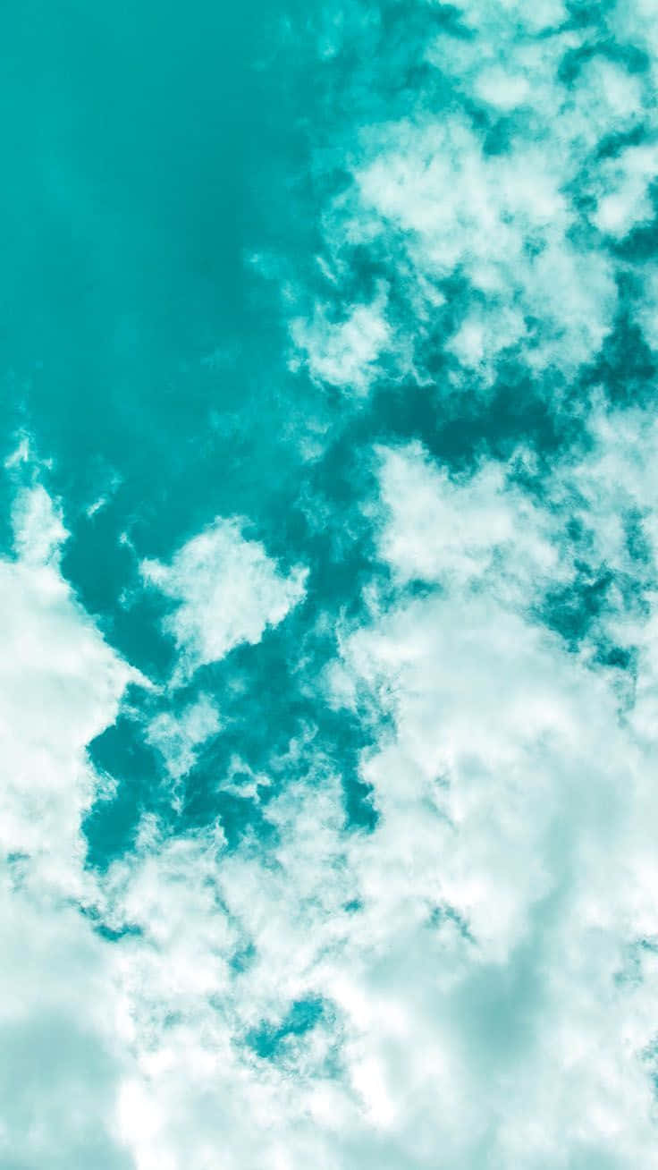 Turquoise 桌布 壁紙 — 充滿活力的藍綠色天空，柔軟的白雲在明亮開闊的大氣中飄移。