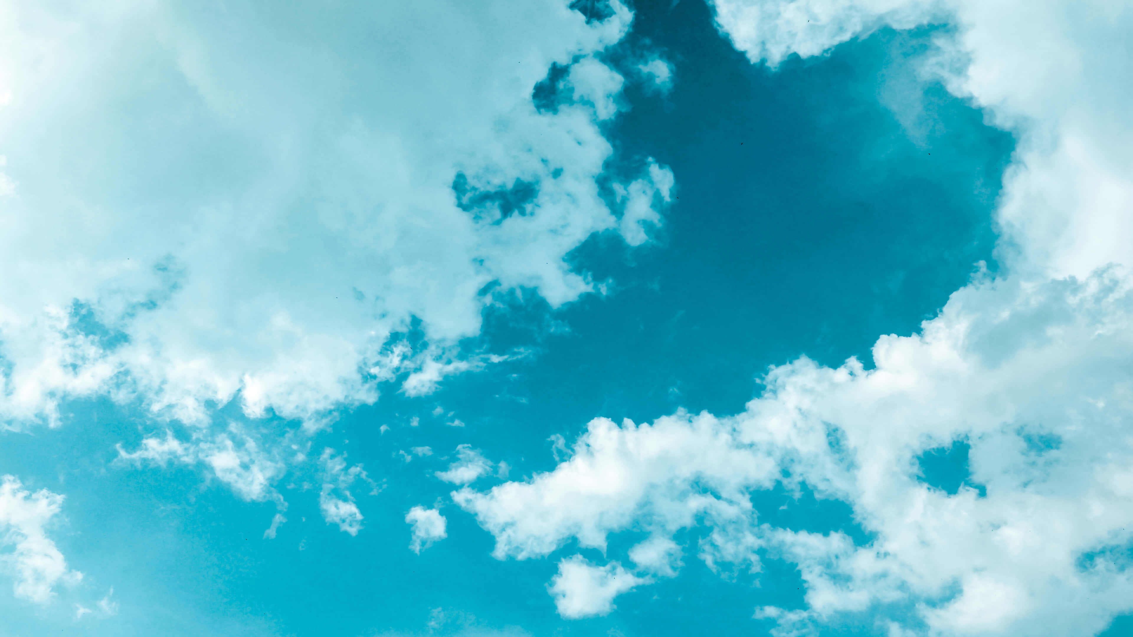 Clouds Aesthetics 桌布 壁紙 — 充滿活力的藍綠色天空，飄浮著蓬鬆的白雲，在明亮的白天中移動。
