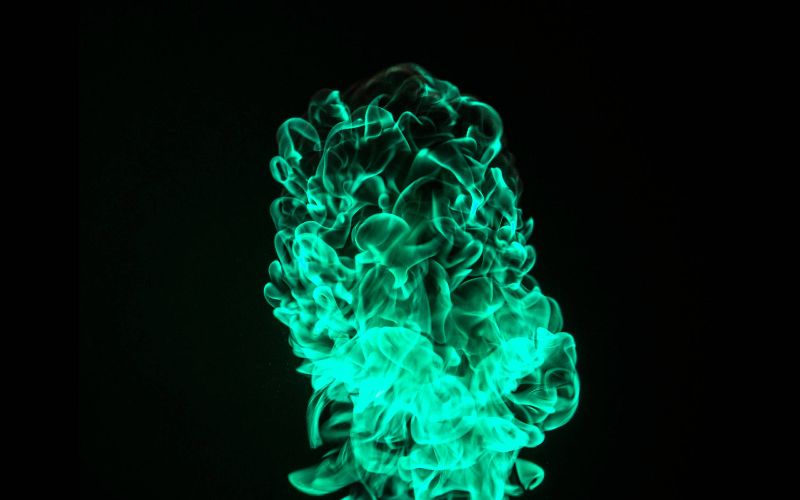 Green Fire 桌布 壁紙 — 充滿活力的藍綠色煙霧在純黑色背景上動態旋轉，營造出空靈發光的效果。