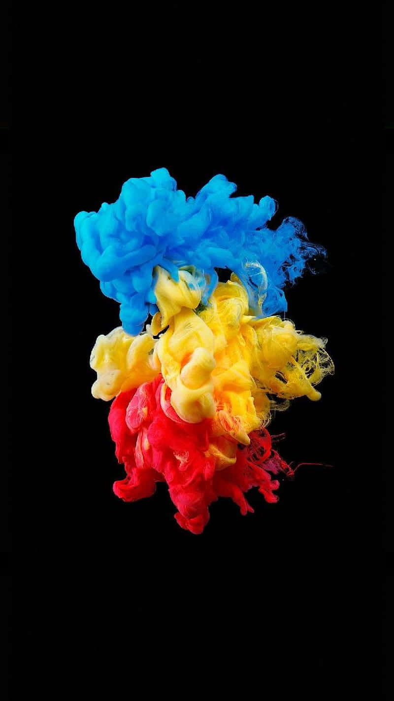 Colorful Smoke 桌布 壁紙 — 充滿活力的藍色、黃色和紅色墨水在鮮明的黑色背景上動態旋轉，形成生動的抽象爆炸效果。
