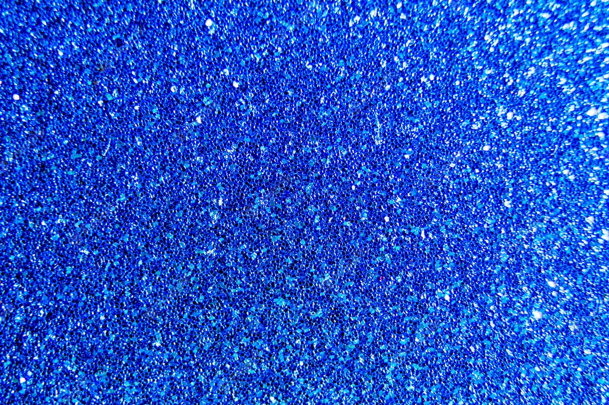 Blue Sparkle 桌布 壁紙 — 充滿活力的藍色亮粉特寫，帶有閃爍的高光和深邃陰影，營造出有紋理、閃閃發光的表面。