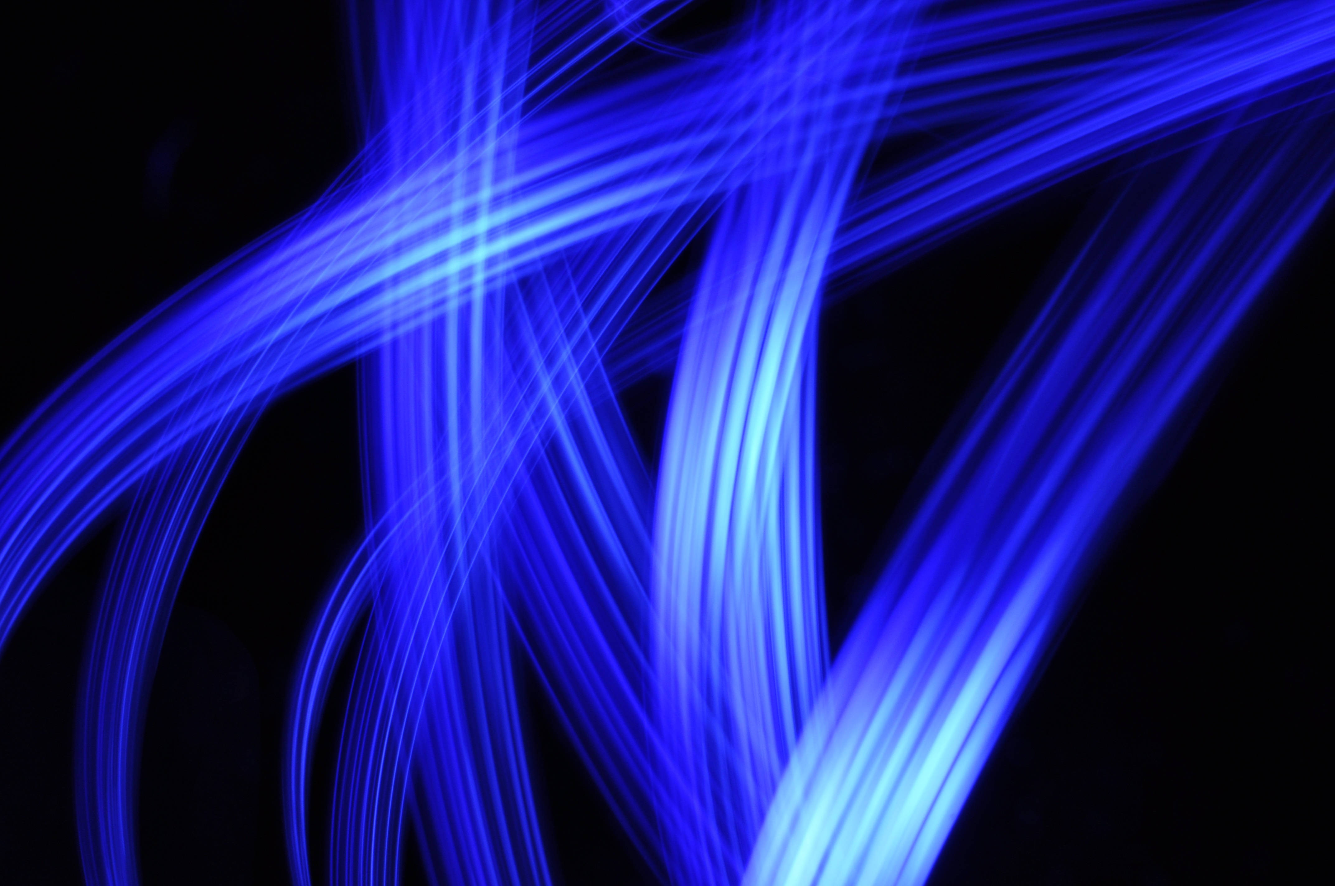 Flash 桌布 壁紙 — 充滿活力的藍色光線在深黑色背景上動態流動，形成迷人的抽象圖案。