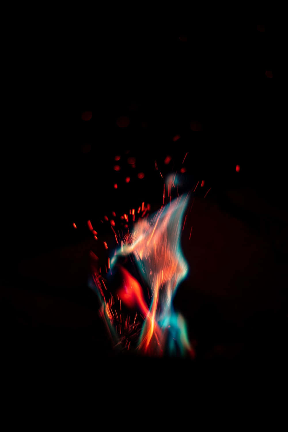 Digital 桌布 壁紙 — 充滿活力的藍色和橙色火焰條紋在漆黑的背景上爆發，散落著發光的餘燼。