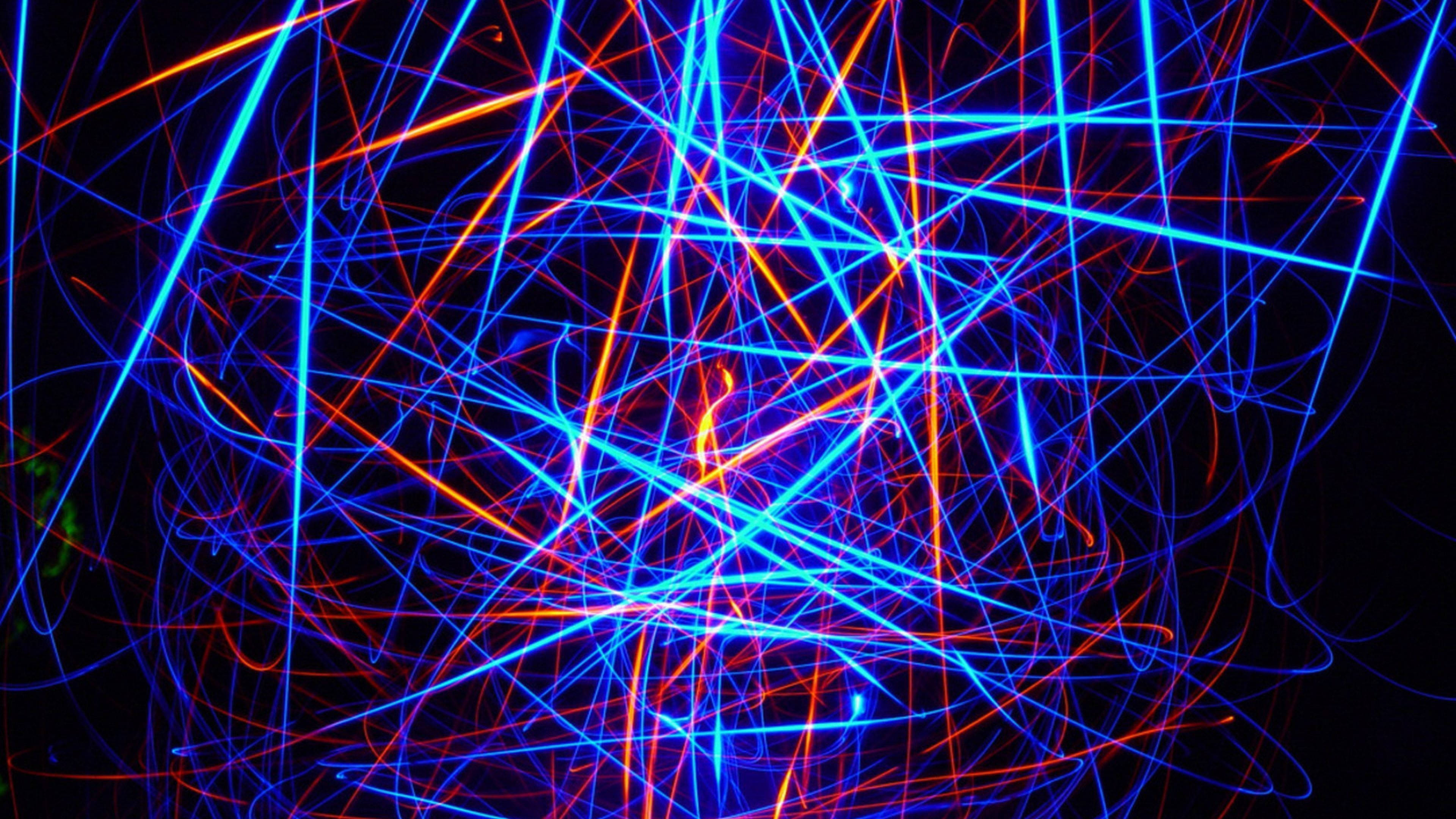 Neon Light 桌布 壁紙 — 充滿活力的藍色和橙色雷射光束在黑色虛空中以混亂、充滿能量的圖案劃過。
