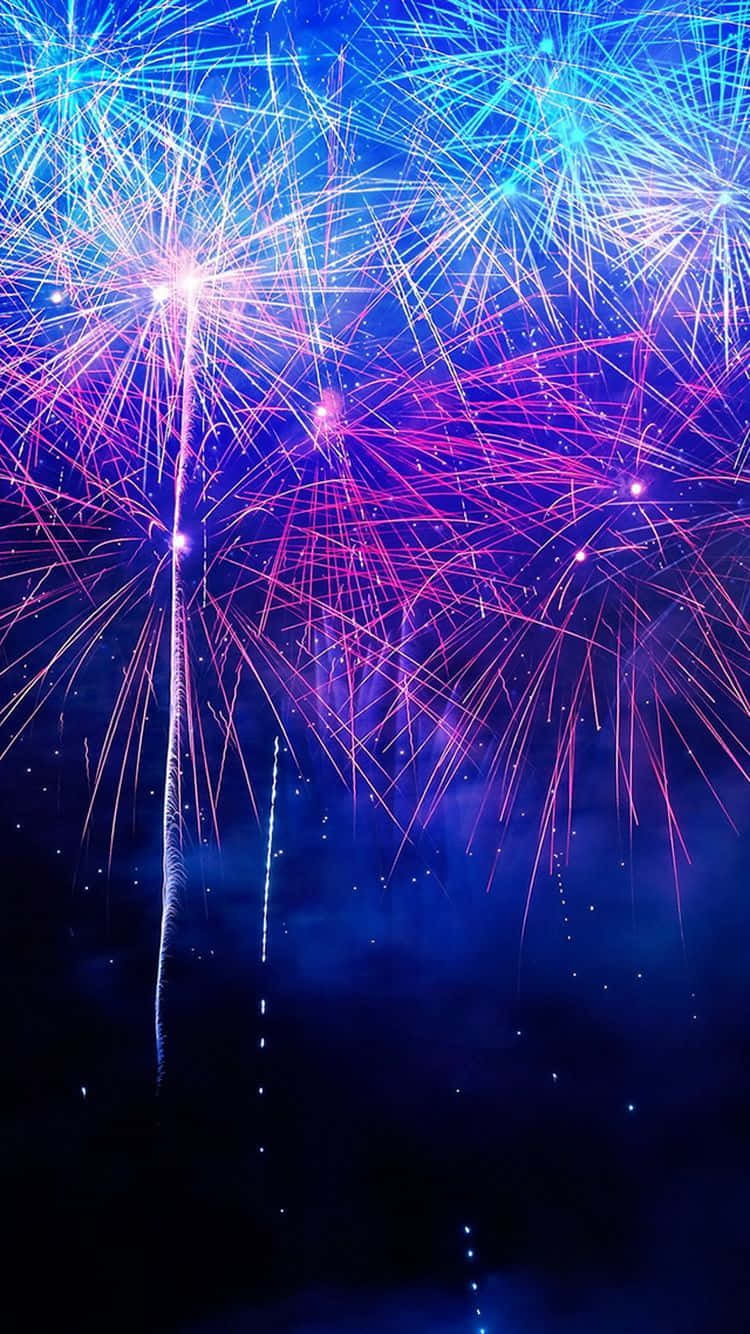 Fireworks 桌布 壁紙 — 充滿活力的藍色和粉紅色煙火在漆黑的夜空中爆炸，形成耀眼的流光。