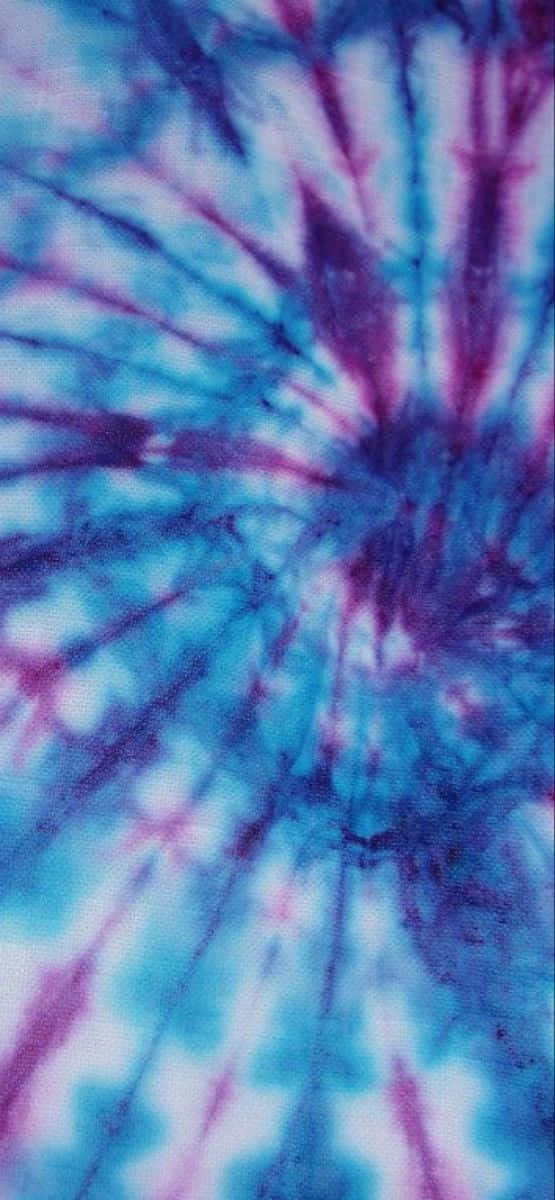 Blue Tie Dye 桌布 壁紙 — 充滿活力的藍色和紫色紮染圖案在布料上向外輻射成星爆設計。