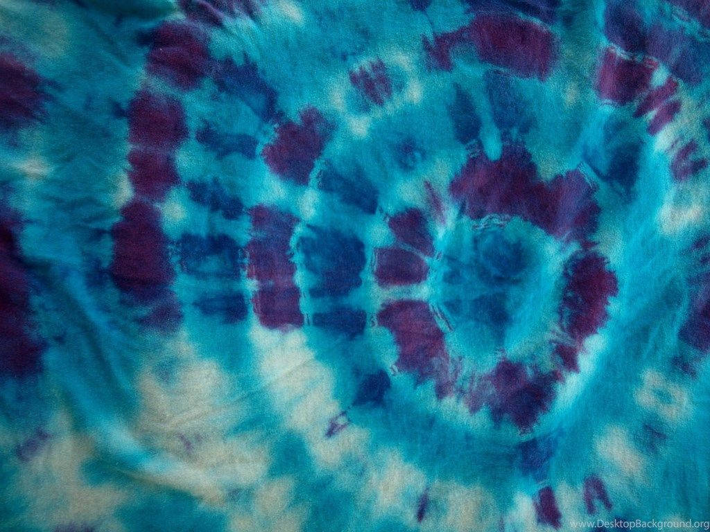 dye 桌布 壁紙 — 充滿活力的藍色和紫色紮染布料特寫，帶有漩渦螺旋圖案和柔和的白色點綴。