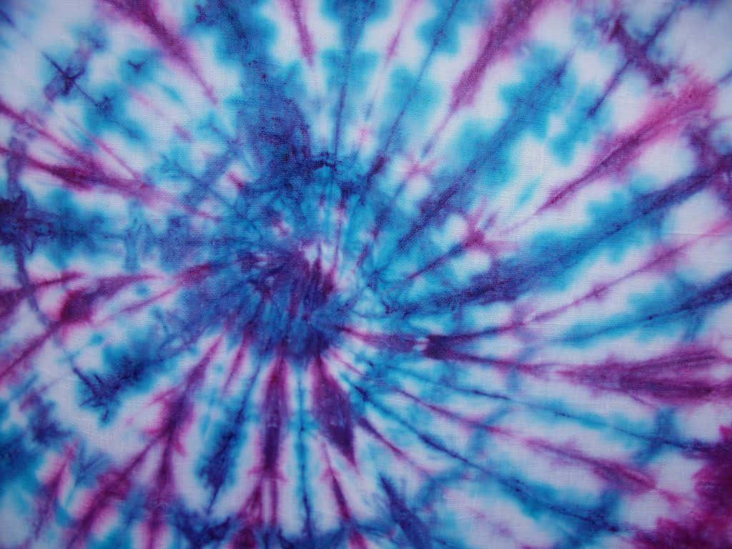 Pastel Tie Dye 桌布 壁紙 — 充滿活力的藍色和紫色紮染漩渦從白色布料背景的中心點向外輻射。