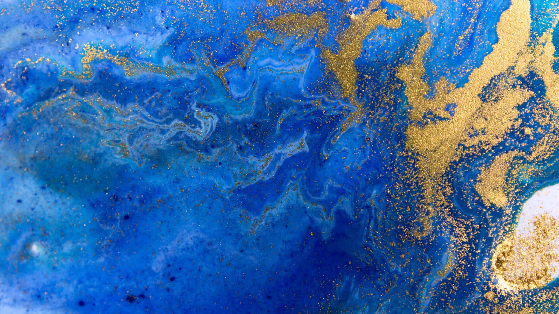 Blue Marble 桌布 壁紙 — 充滿活力的藍色和金色抽象流體藝術，帶有漩渦圖案和閃閃發光的斑點。