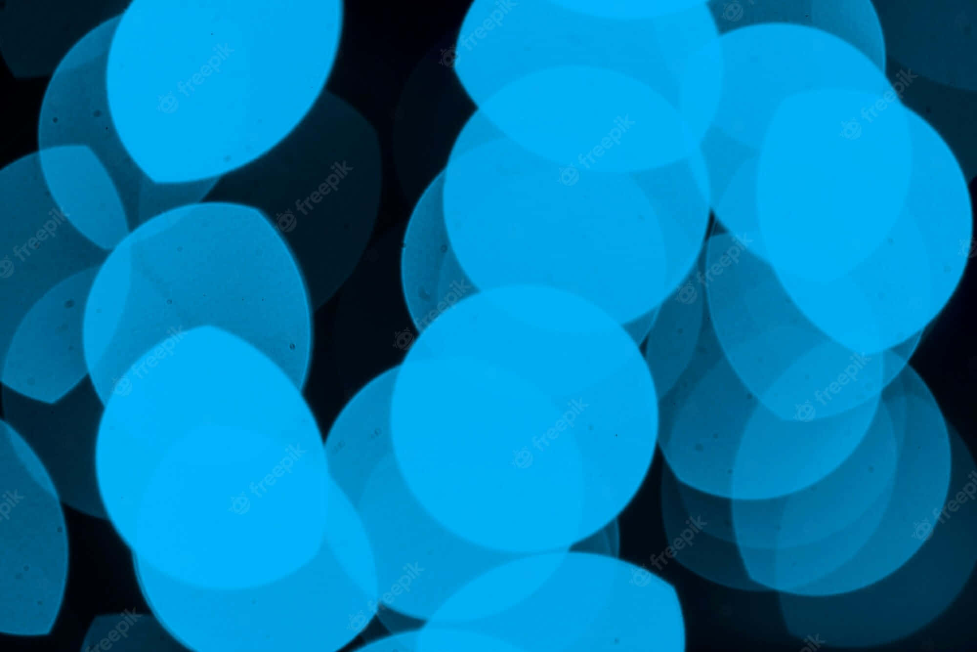 Blue Led 桌布 壁紙 — 充滿活力的藍色圓形散景燈光在深黑色背景上柔和發光，營造出夢幻般的抽象圖案。