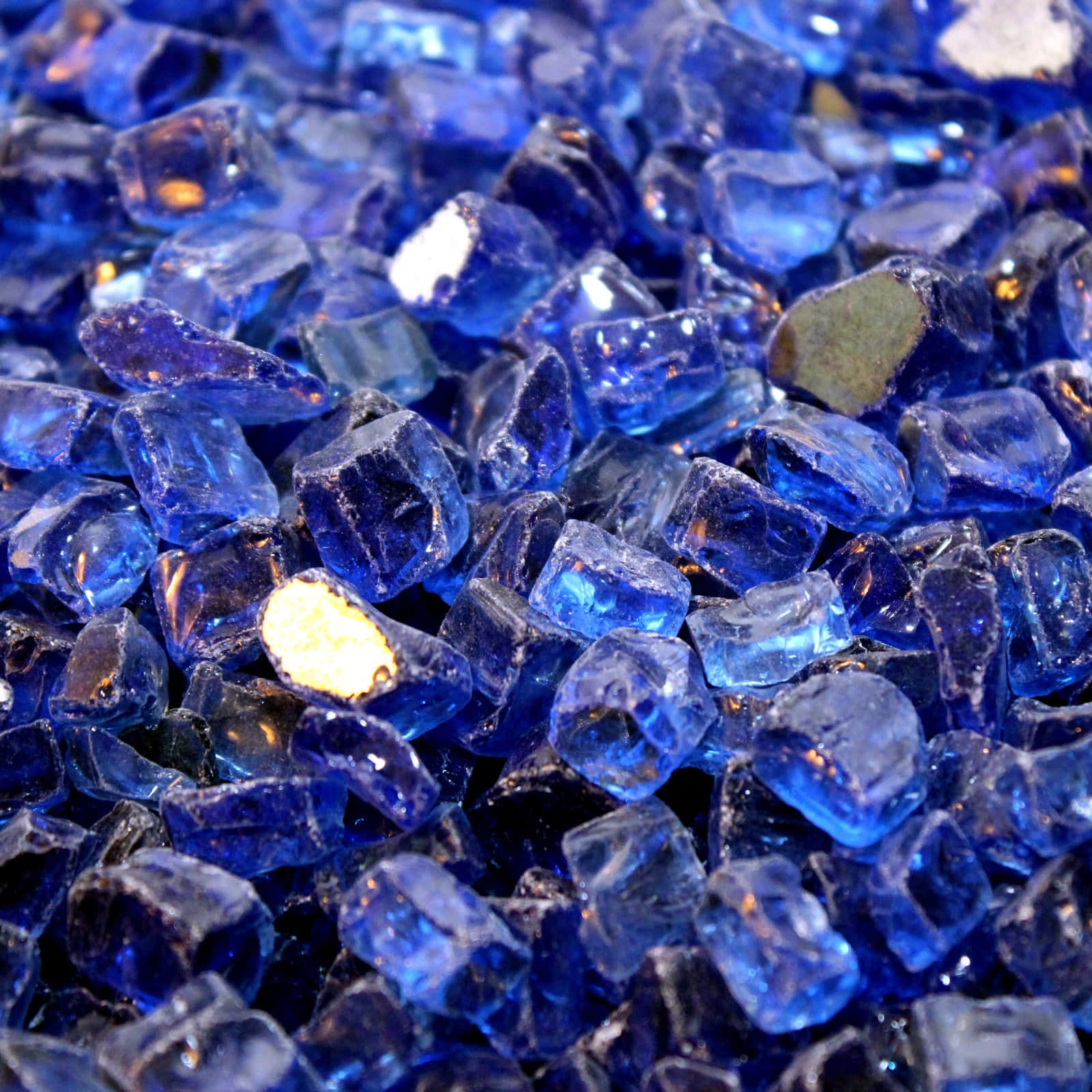 Cobalt Blue 桌布 壁紙 — 充滿活力的藍色玻璃寶石近距離特寫，金色斑點在閃爍的堆中捕捉光線。
