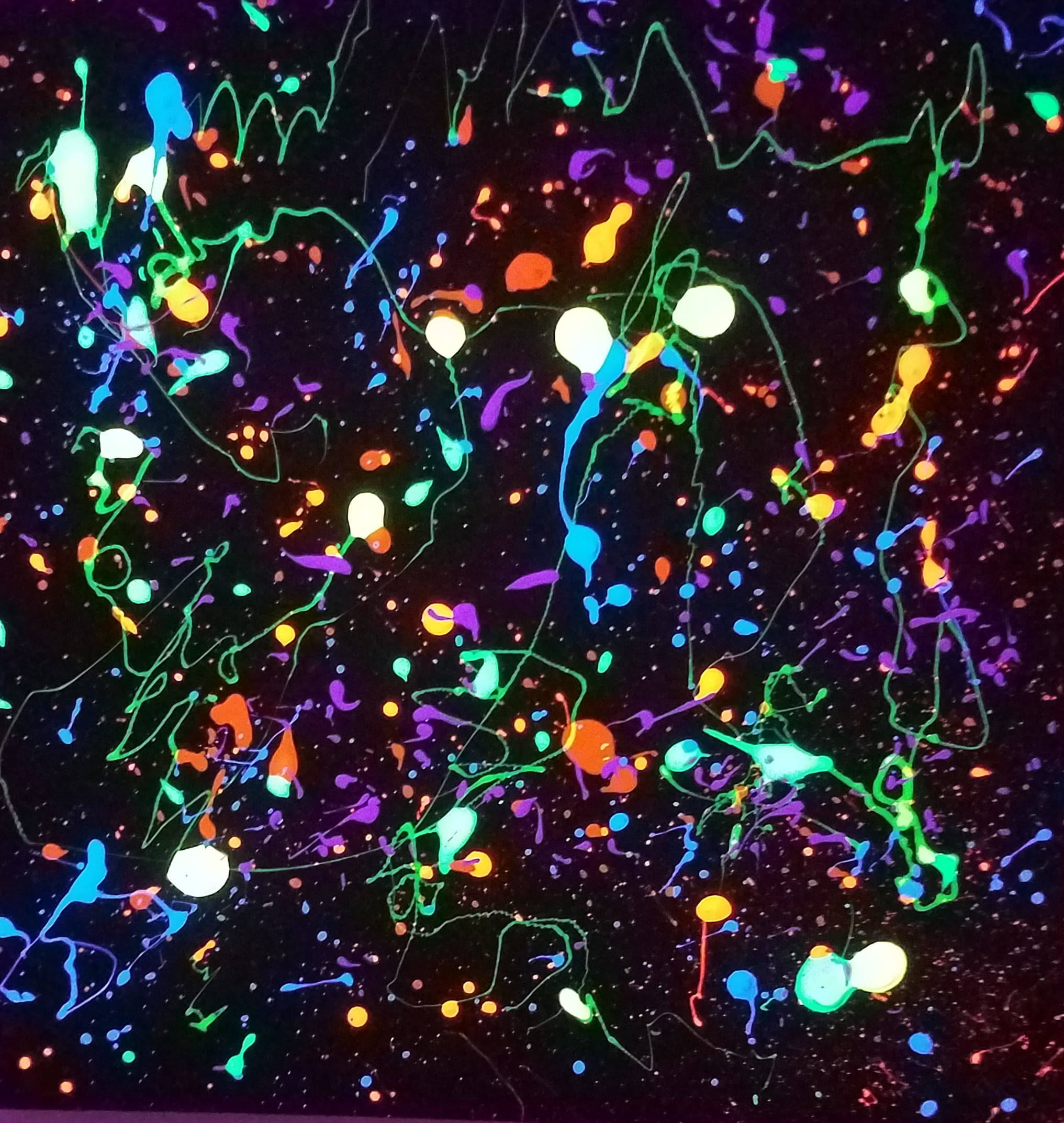 Splatter Paint 桌布 壁紙 — 充滿活力的螢光顏料飛濺和滴落在漆黑的背景上，形成混亂的抽象色彩爆炸。