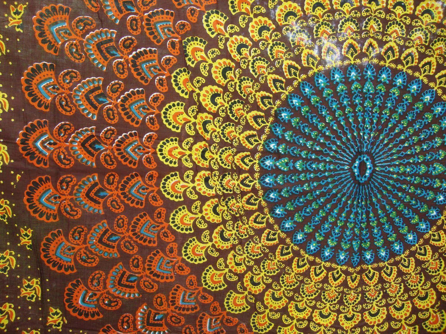 嬉皮 桌布 壁紙 — 充滿活力的蠟染布料在深棕色背景上展現出從中心點放射的複雜橙色、黃色和藍色曼陀羅圖案。