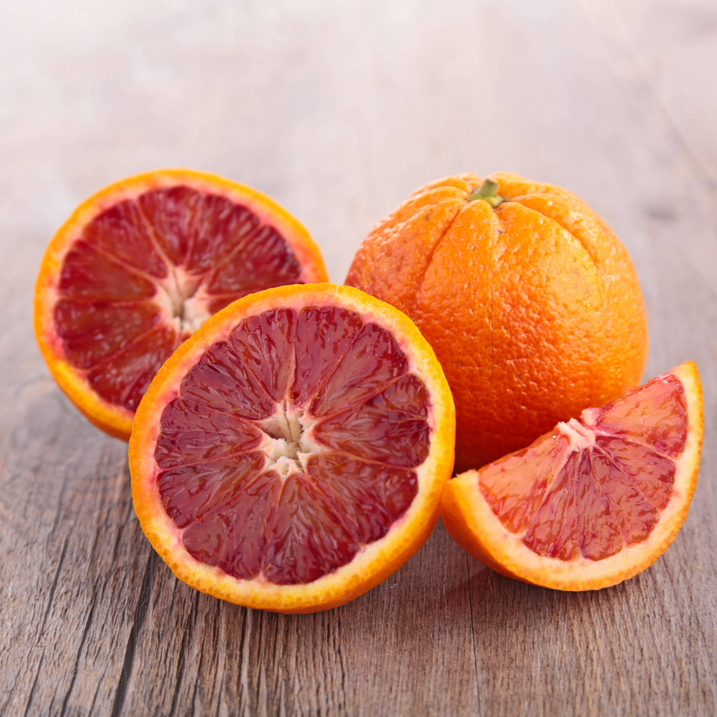 Fruit 桌布 壁紙 — 充滿活力的血橙切開，露出深紅色的果肉，放在質樸的木質表面上。