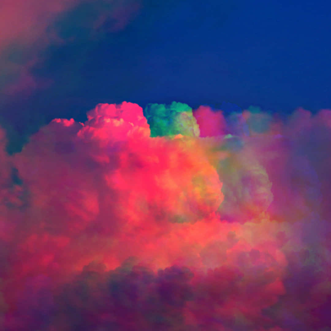 Colorful Aesthetic 桌布 壁紙 — 充滿活力的超現實雲朵在深藍色天空背景下爆炸出霓虹粉紅、綠色和紫色。