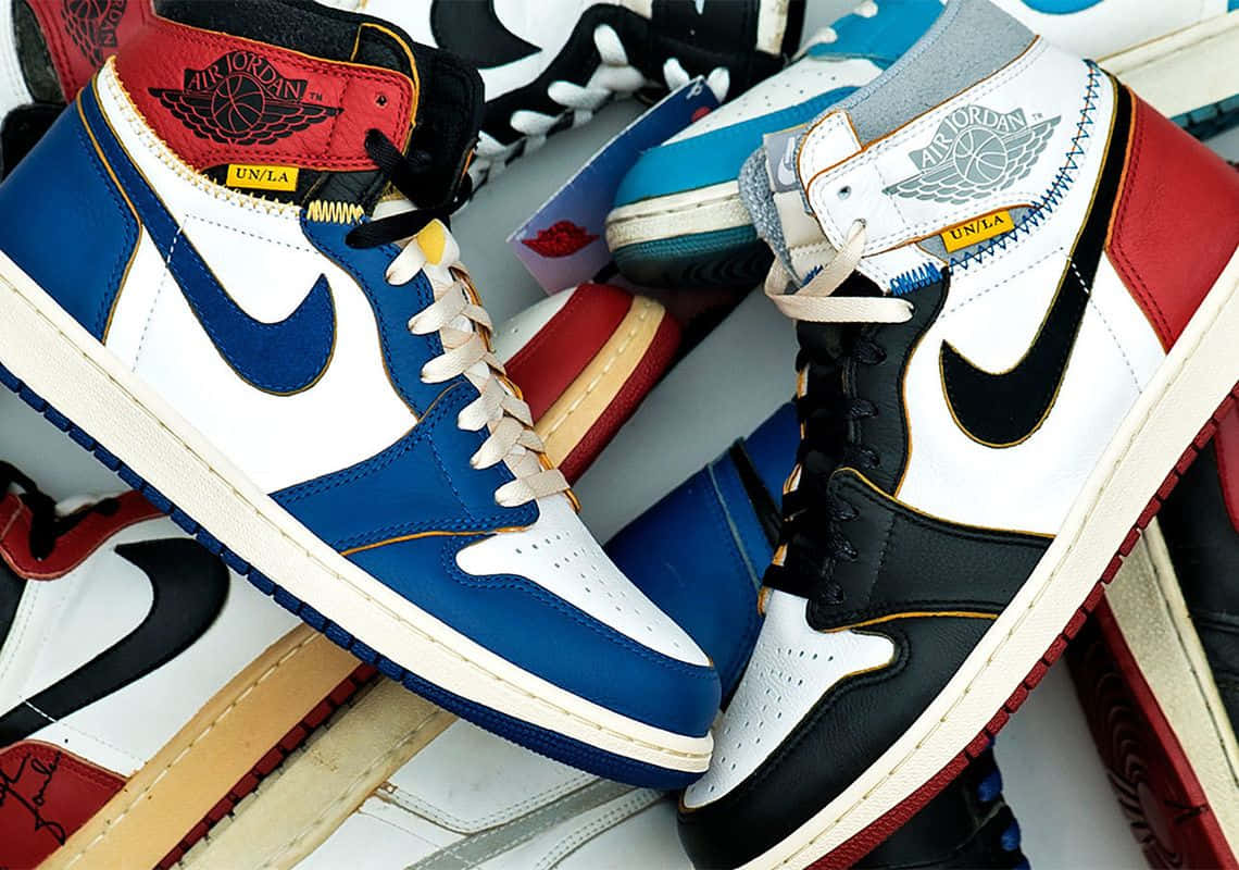 Air Jordan 1 桌布 壁紙 — 充滿活力的近距離拍攝，展示大膽藍、白、黑色調的奢華 Air Jordan 運動鞋堆疊在一起。