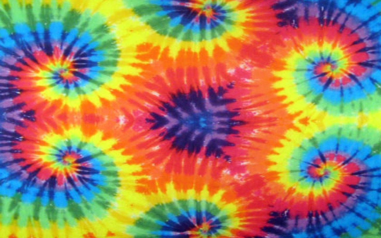 dye 桌布 壁紙 — 充滿活力的迷幻紮染漩渦在紋理織物表面上以彩虹色調爆發。