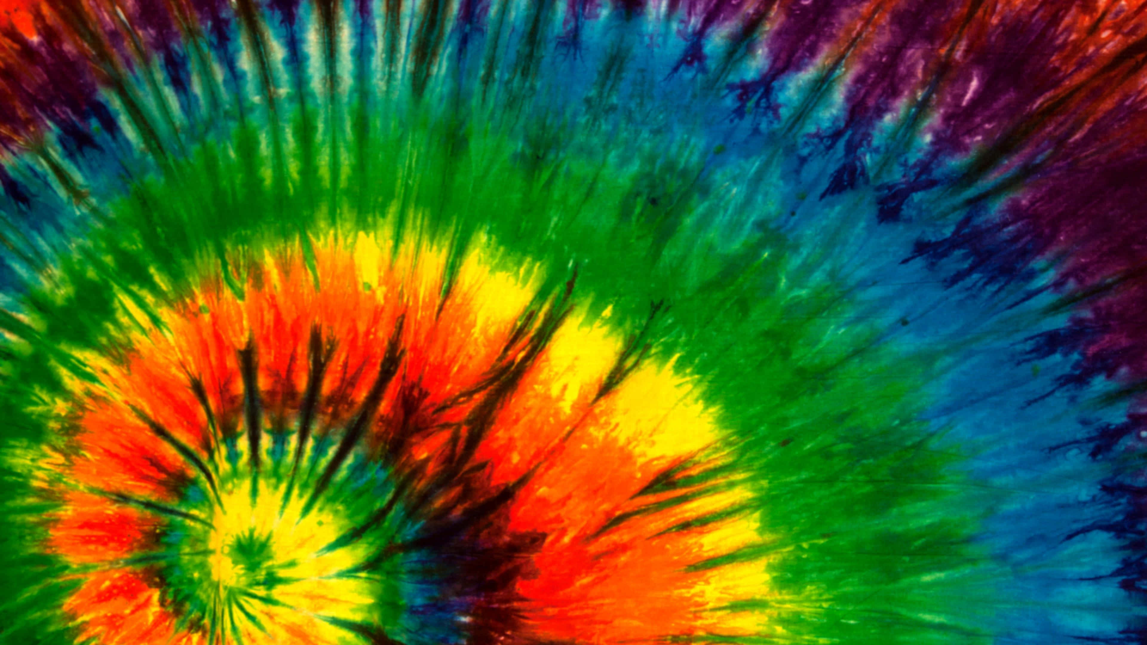 High Resolution Tie Dye 桌布 壁紙 — 充滿活力的迷幻紮染漩渦從明亮的中心散發出大膽的彩虹色和黑色條紋。