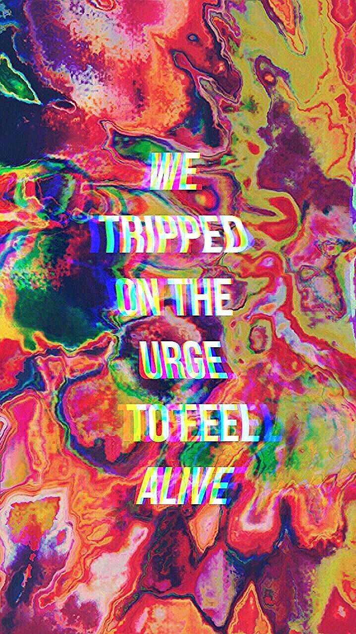 Trippy Dope 桌布 壁紙 — 充滿活力的迷幻霓虹色漩渦形成一個迷幻的抽象背景，帶有發光的故障文字，寫著 'WE TRIPPED ON THE URGE TO FEEL ALIVE'。