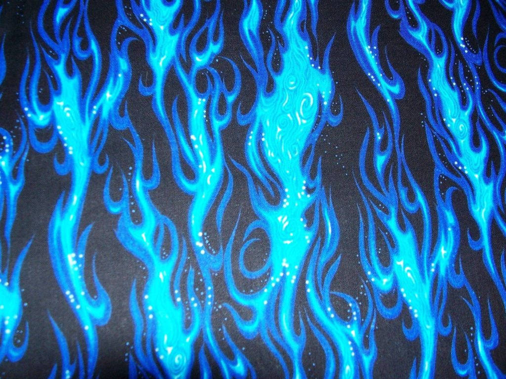 Blue Fire 桌布 壁紙 — 充滿活力的電藍色火焰圖案在深色布料表面上旋轉，帶有發光的白色斑點。