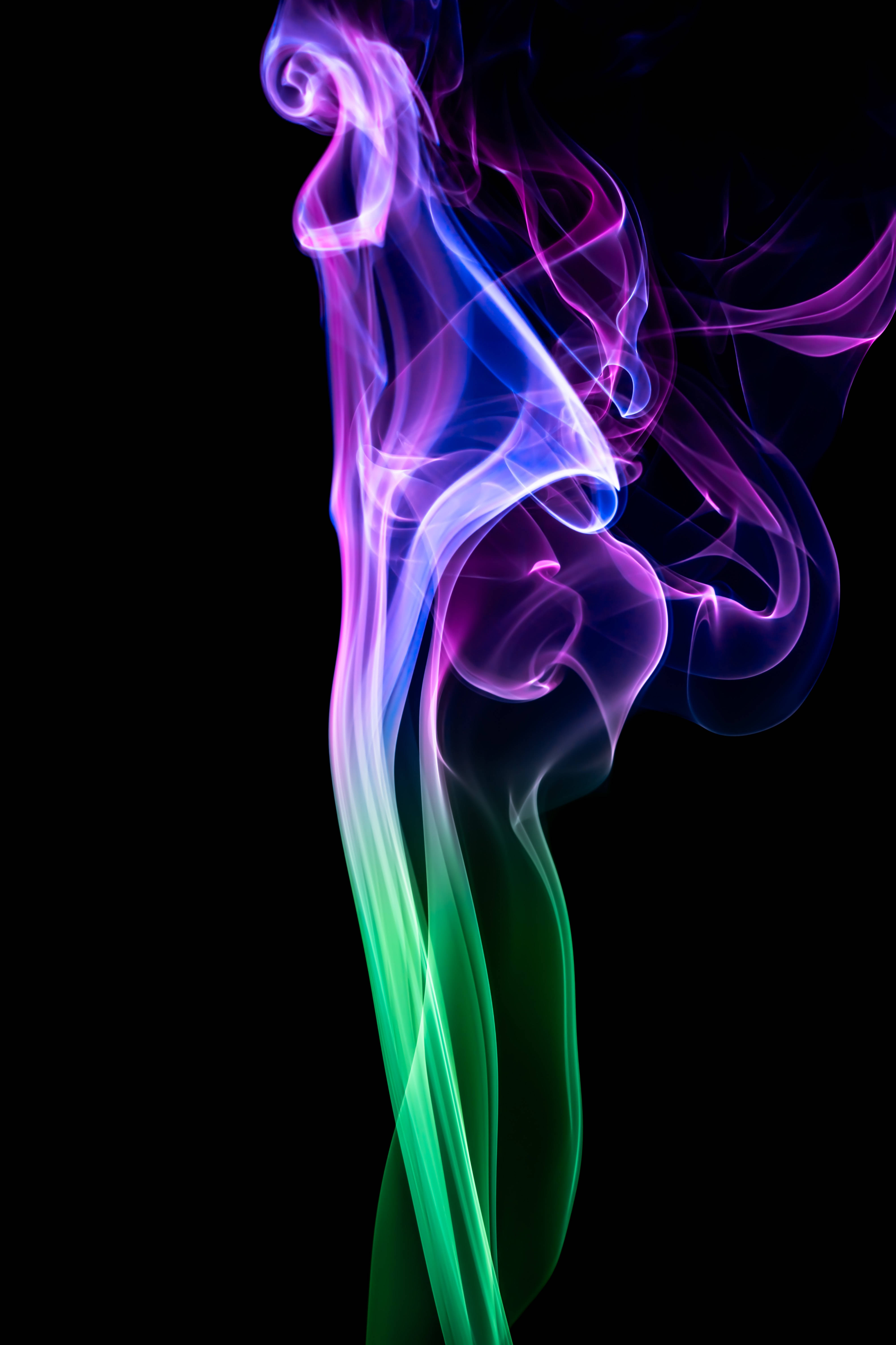 抽象 桌布 壁紙 — 充滿活力的霓虹煙霧，紫色、藍色和綠色的漩渦在純黑色背景上優雅地升起。